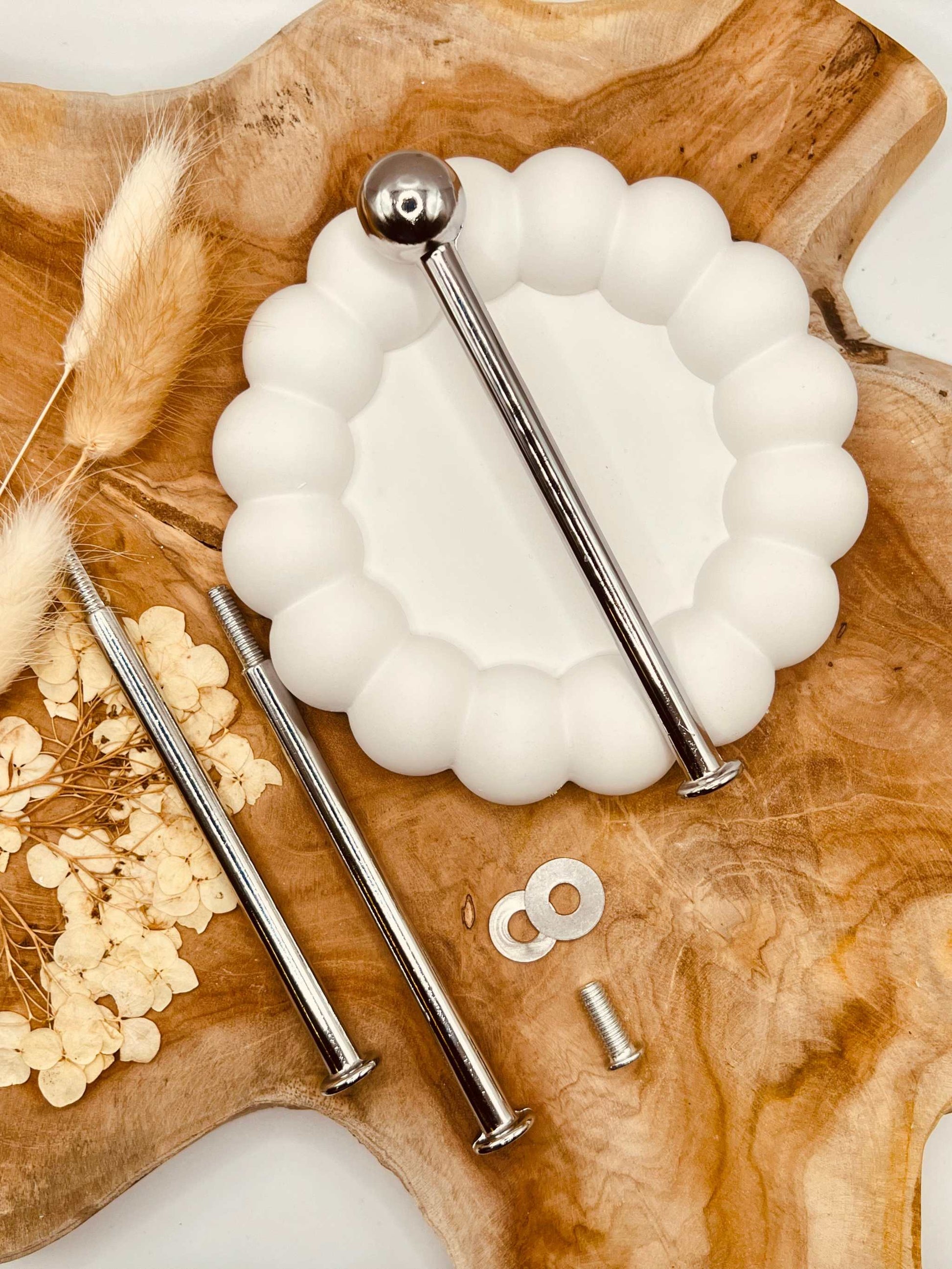 Detailansicht der silberfarbenen Etagerenstange mit “Bullet”-Motiv