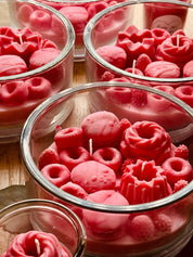 Duftkerze in Rosa und Pink im Glas, verziert mit Wachsbonbons und Süßigkeiten – ein verspieltes Geschenk und dekorative Bereicherung