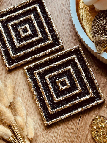 2 resin coasters in black and gold 3D design