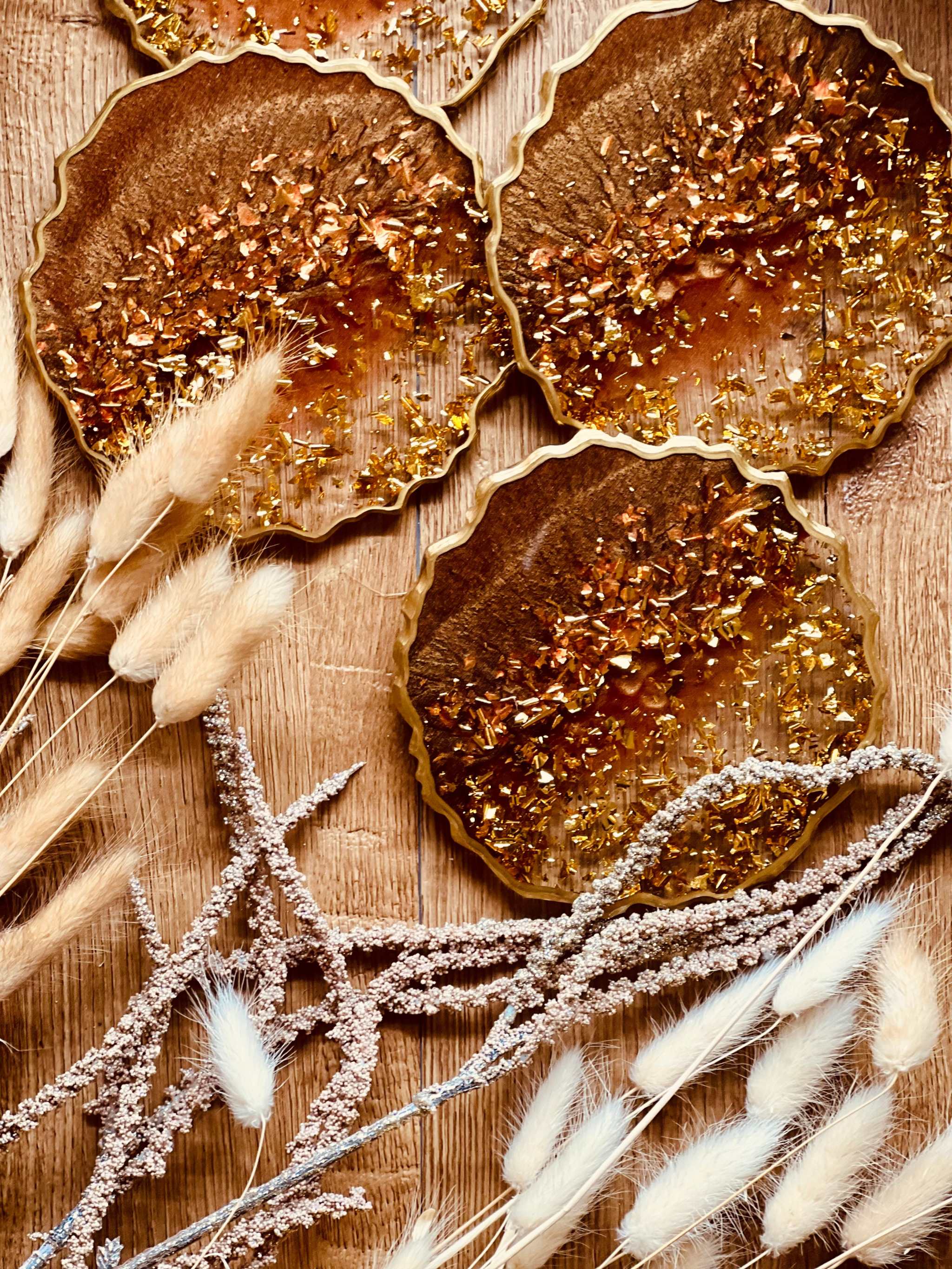 Set aus 4 handgemachten braunen Resin-Untersetzern mit goldenen Details auf Holztisch