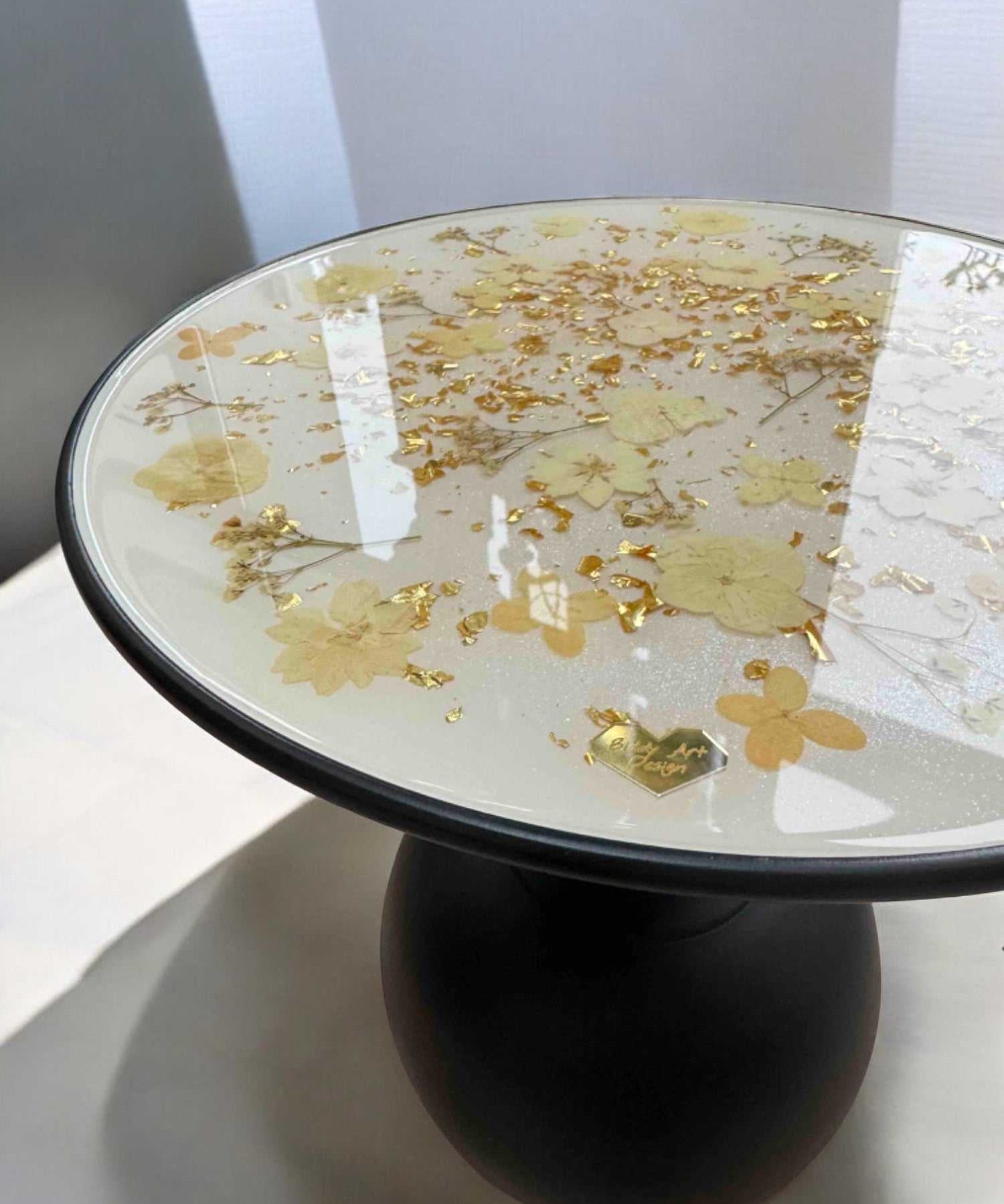 Epoxidharz Couchtisch mit feinen Blüten in Cremeweiß und Blattgold – glänzende Oberfläche, stabiler schwarzer Standfuß, hochwertiges Unikat