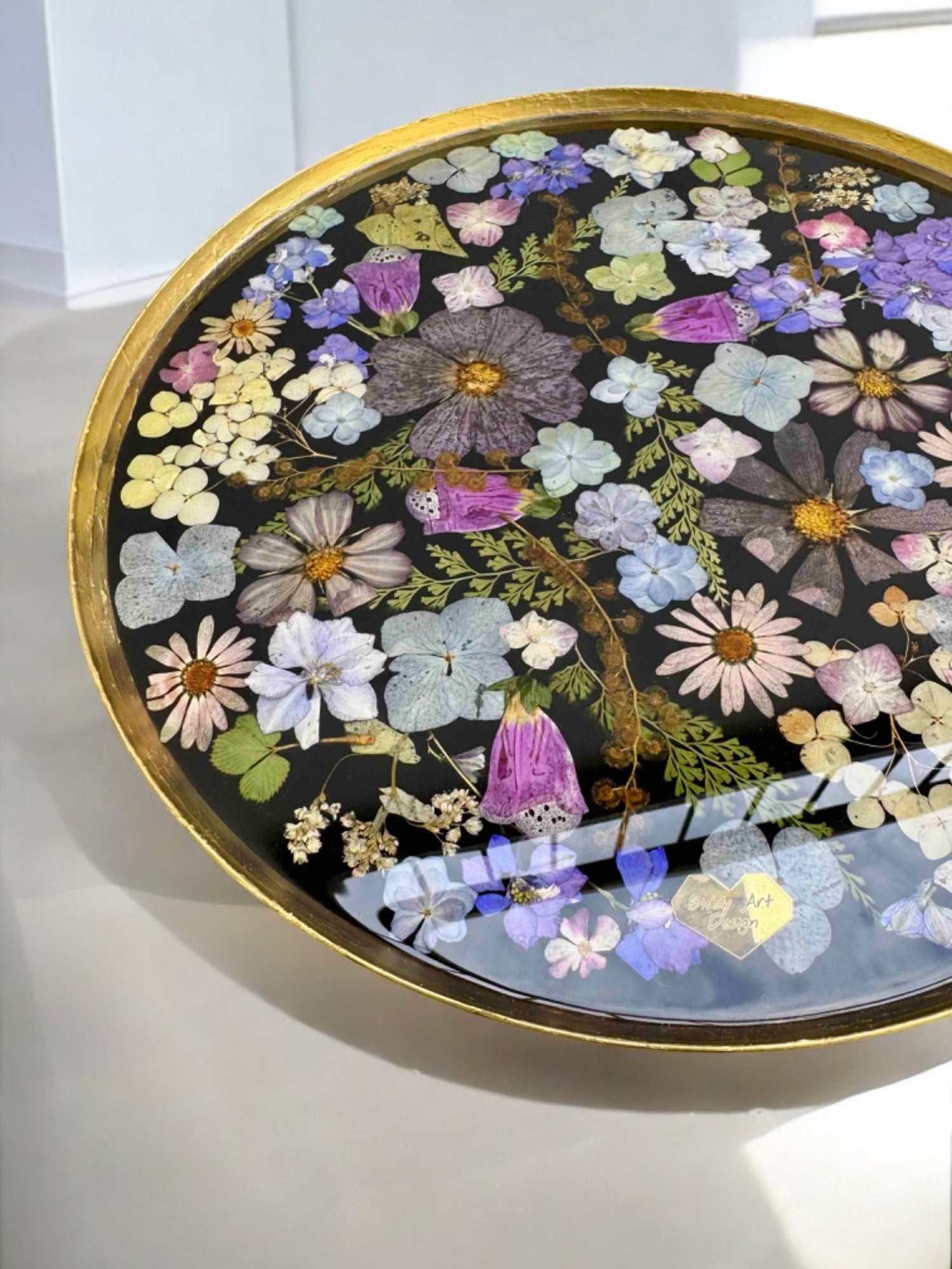 Epoxidharz Couchtisch mit unzähligen echten Blüten in kräftigen Farben – runde Metallplatte mit schwarzem Gestell, dekorativ und einzigartig