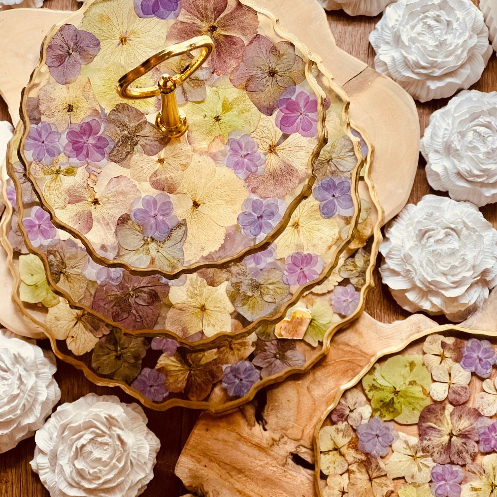 Handgefertigte Resin Etagere mit naturfarbenen und violetten Hortensien, ergänzt durch goldene Details. Perfekt für festliche Dekorationen.