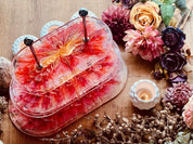 Handgefertigte ovale Resin Etagere in Rot transparent, 3-stöckig, perfekt als elegante Tischdeko oder stilvolle Geschenkidee für besondere Anlässe.Epoxidharz Etagere Kuchenstaender oval mit 3D Design in Rot Weiss Gelb