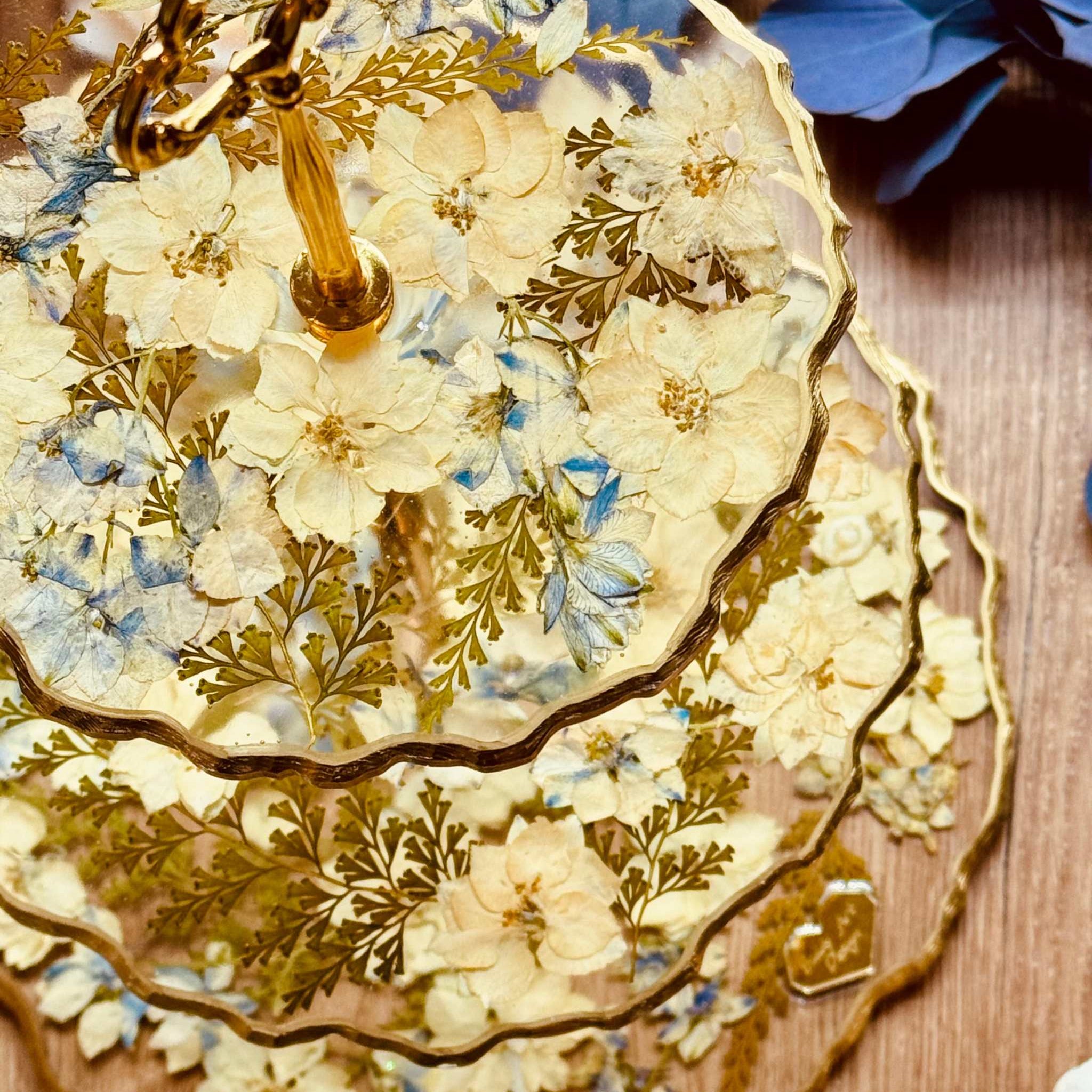 Blattgold trifft auf pastellige Blumen und Farn – eleganter Kuchenständer aus Epoxidharz mit liebevollen Naturdetails