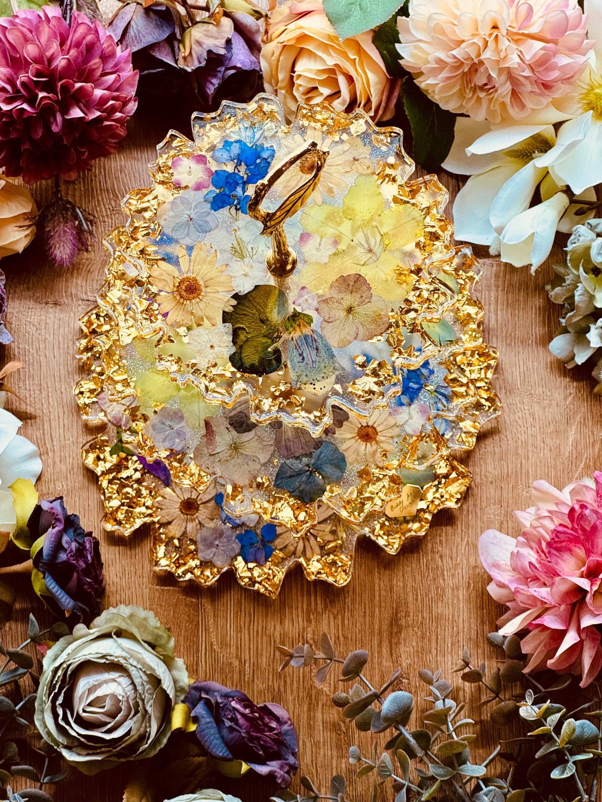 Epoxidharz Etagere mit echten Blumen und goldfarbenen Akzenten – geschwungener Kuchenständer aus Resin mit floraler Optik und glänzendem Blattgold