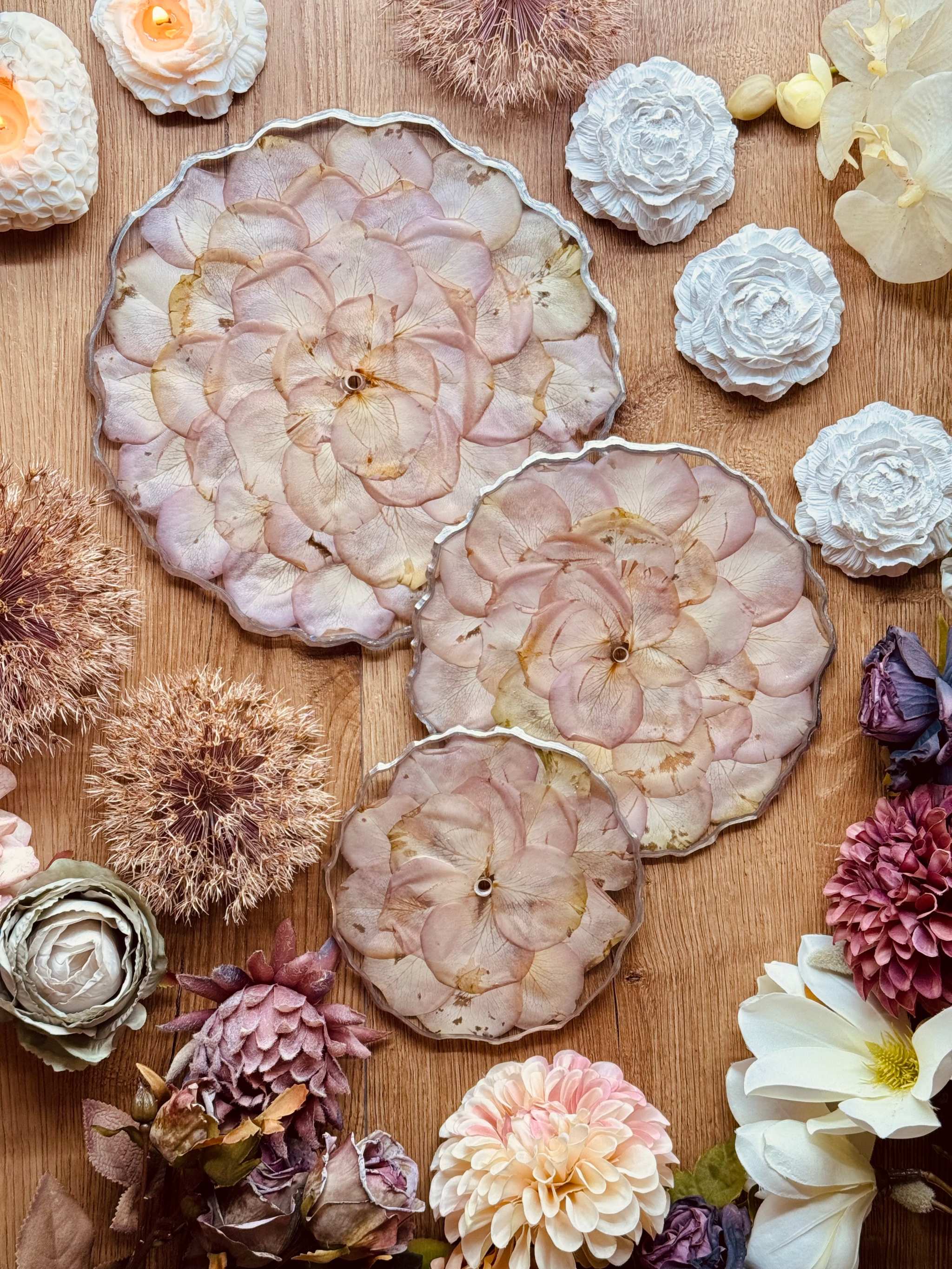 Epoxidharz Etagere mit getrockneten rosa Rosenblättern und silbernen Details auf Holztisch mit Dekoblumen