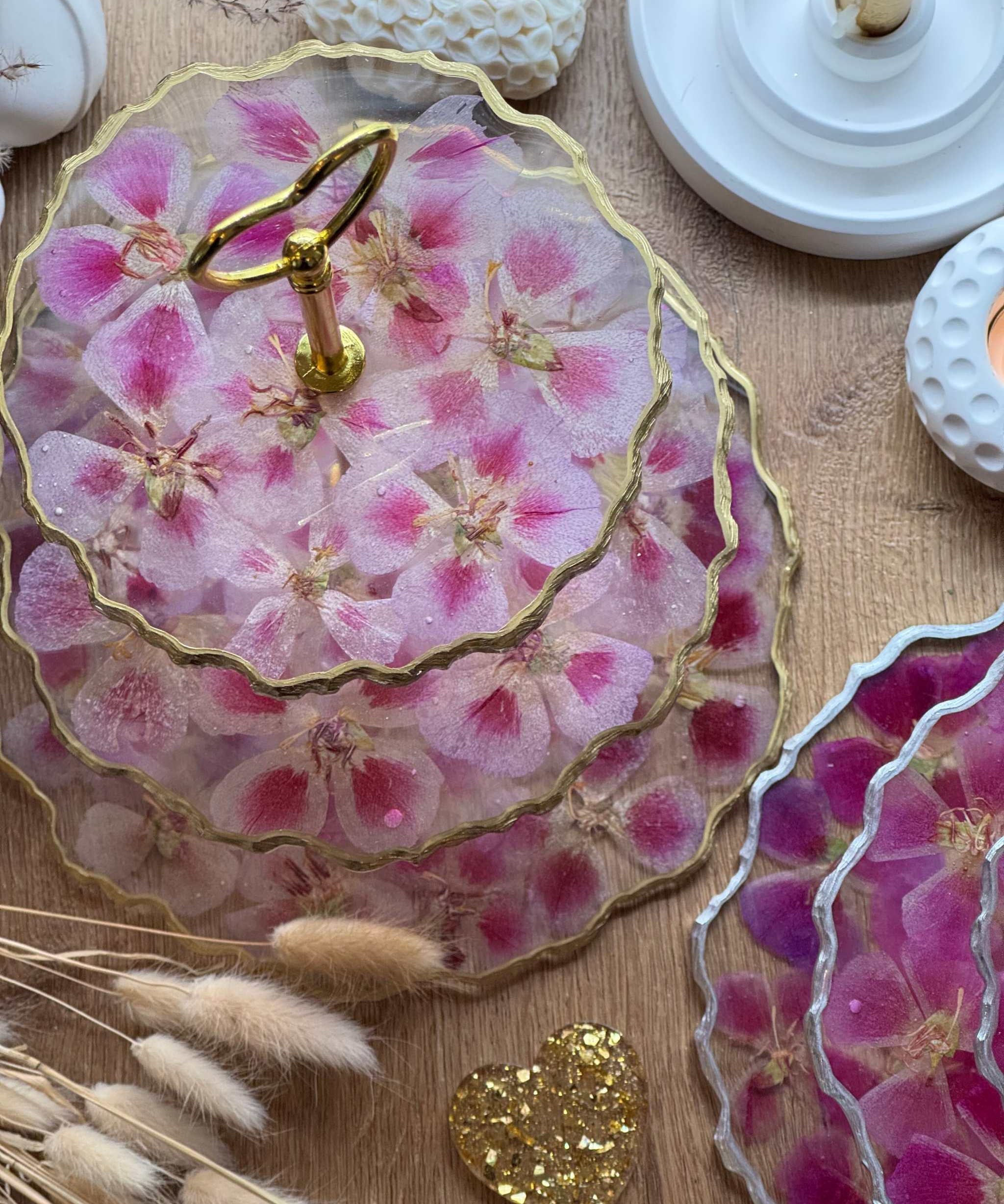 Epoxidharz Etagere aus Resin mit pinken und rosa Blüten auf Holzoberfläche, goldene Details, dekorative Präsentation.