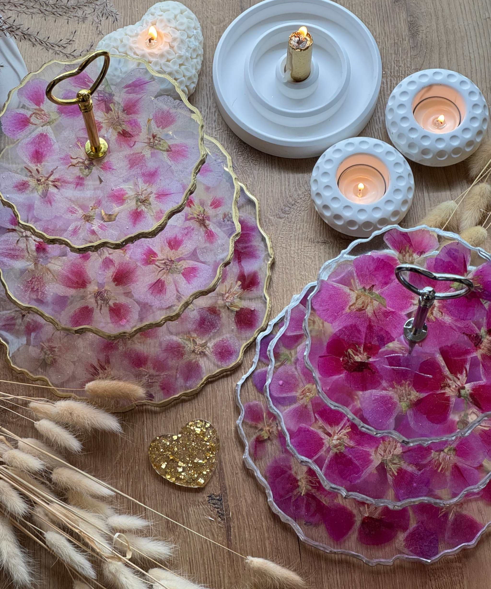 Epoxidharz Etagere aus Resin mit pinken und rosa Blüten, goldenen und silbernen Details, auf Holztisch mit Kerzen.