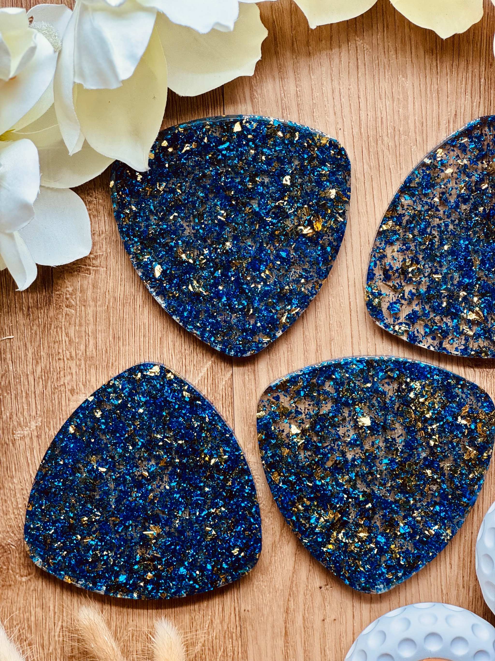 4 Untersetzer aus blauer Resin mit goldenen Akzenten auf Holzuntergrund