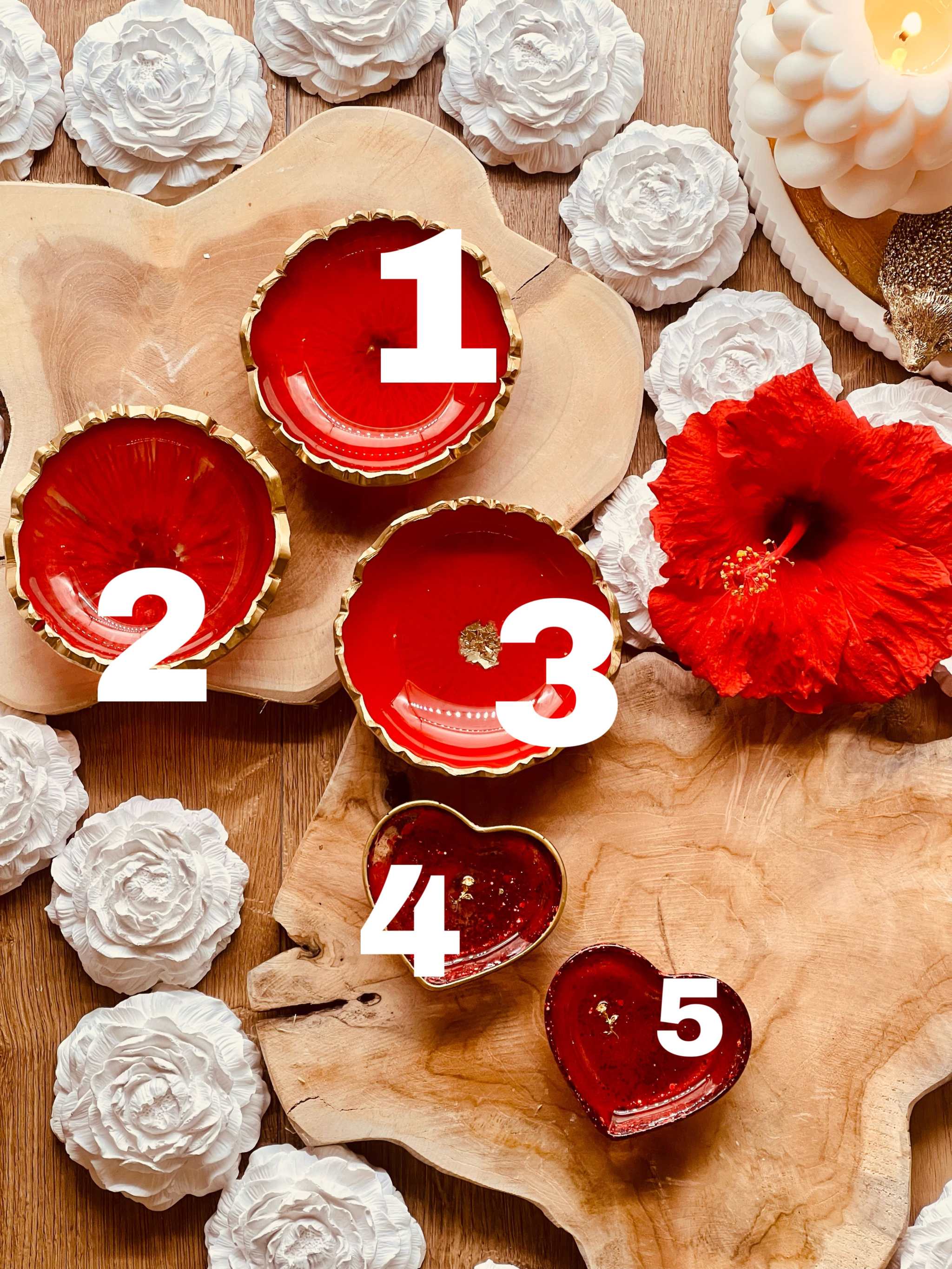 rote handgemachte Schmuckschalen aus Resin mit goldenen Details in Herz- und Rundform auf Holzplatte