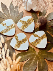 Handgefertigte Gießkeramik-Untersetzer im 4er-Set, verziert mit kunstvollen goldenen Harz-Details, perfekt für stilvolle Getränkeunterlagen.Giesskeramik Weisse Deko Untersetzer mit Blattgold Glanz