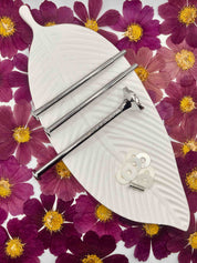 Einzelteile der silberfarbenen Etagerenstange mit Schrauben und Zubehör