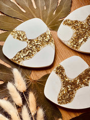 Gießkeramik-Untersetzer im 4er-Set mit glitzernden Gold-Resin-Akzenten, handgefertigt und perfekt, um Tische vor Getränkeflecken zu schützen.Glitzernder Blattgold Untersetzer Giesskeramik Weisse Deko