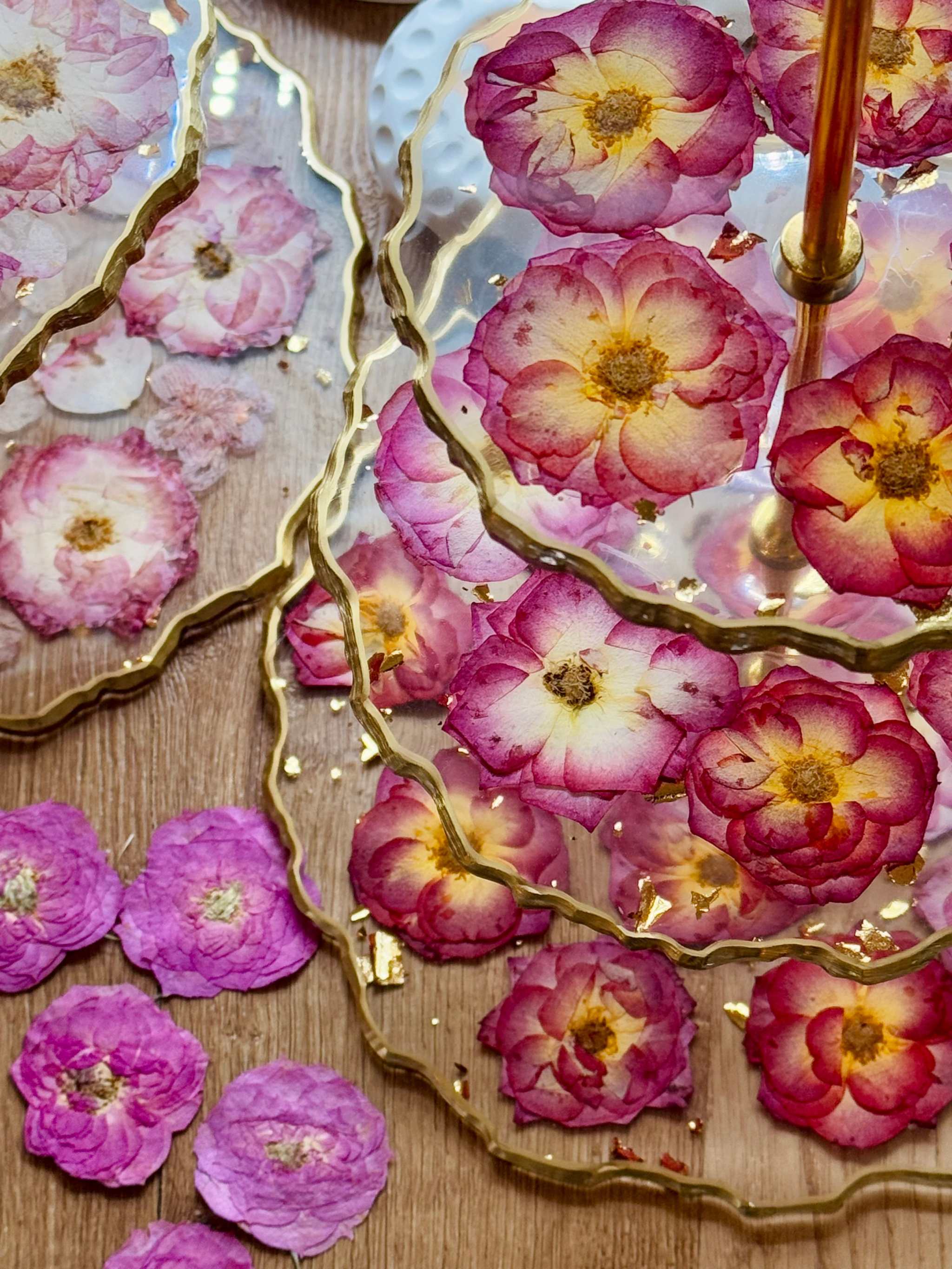 Handgefertigte Epoxidharz Etagere aus Resin mit roten und rosa Rosen sowie goldenen Details, ideal für Tischdekoration.