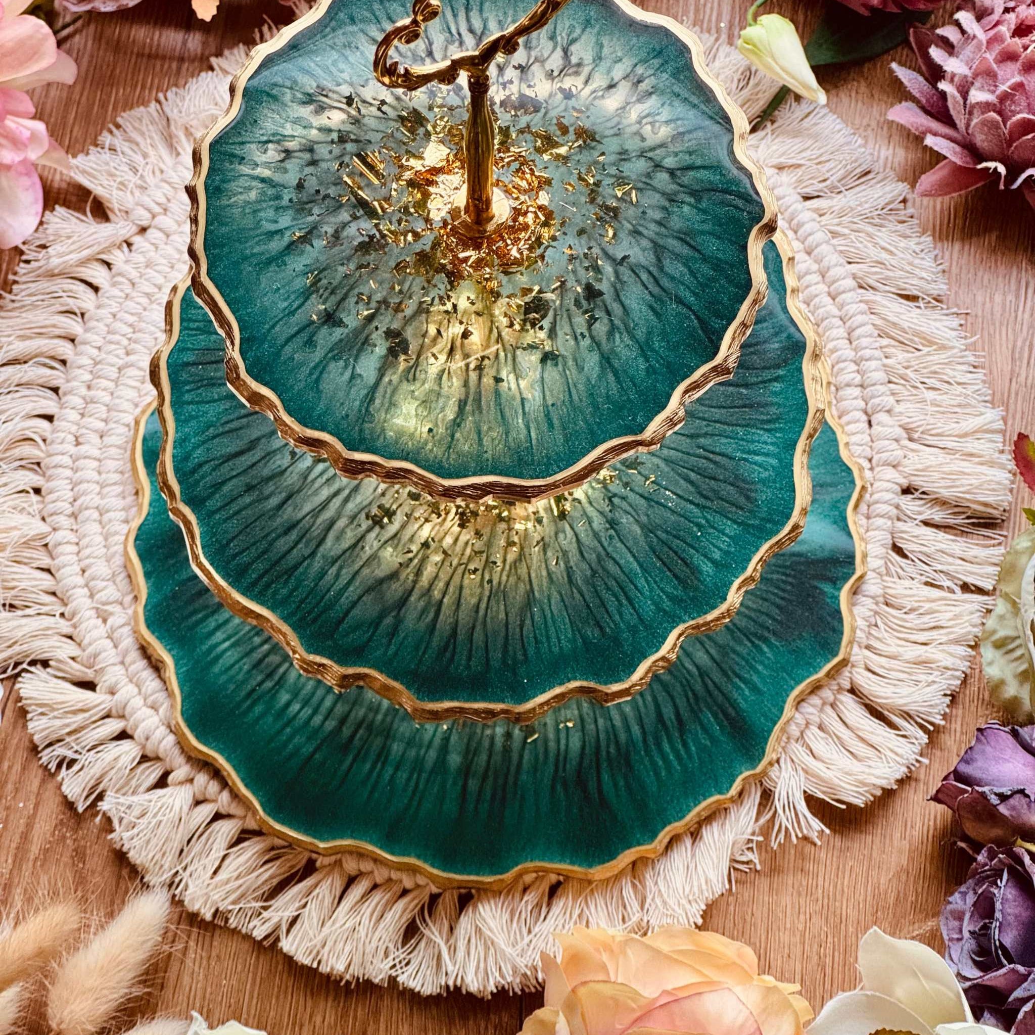 Handgefertigte Epoxidharz Etagere in edlem Grün mit goldenen Akzenten, perfekt für stilvolle Dekoration oder als Servierplatte für besondere Anlässe.

Dekorative 3-stufige Etagere aus hochwertigem Resin, einzigartiges Design in Grün-Gold, ideal für elegante Wohnraumgestaltung oder Feiern.