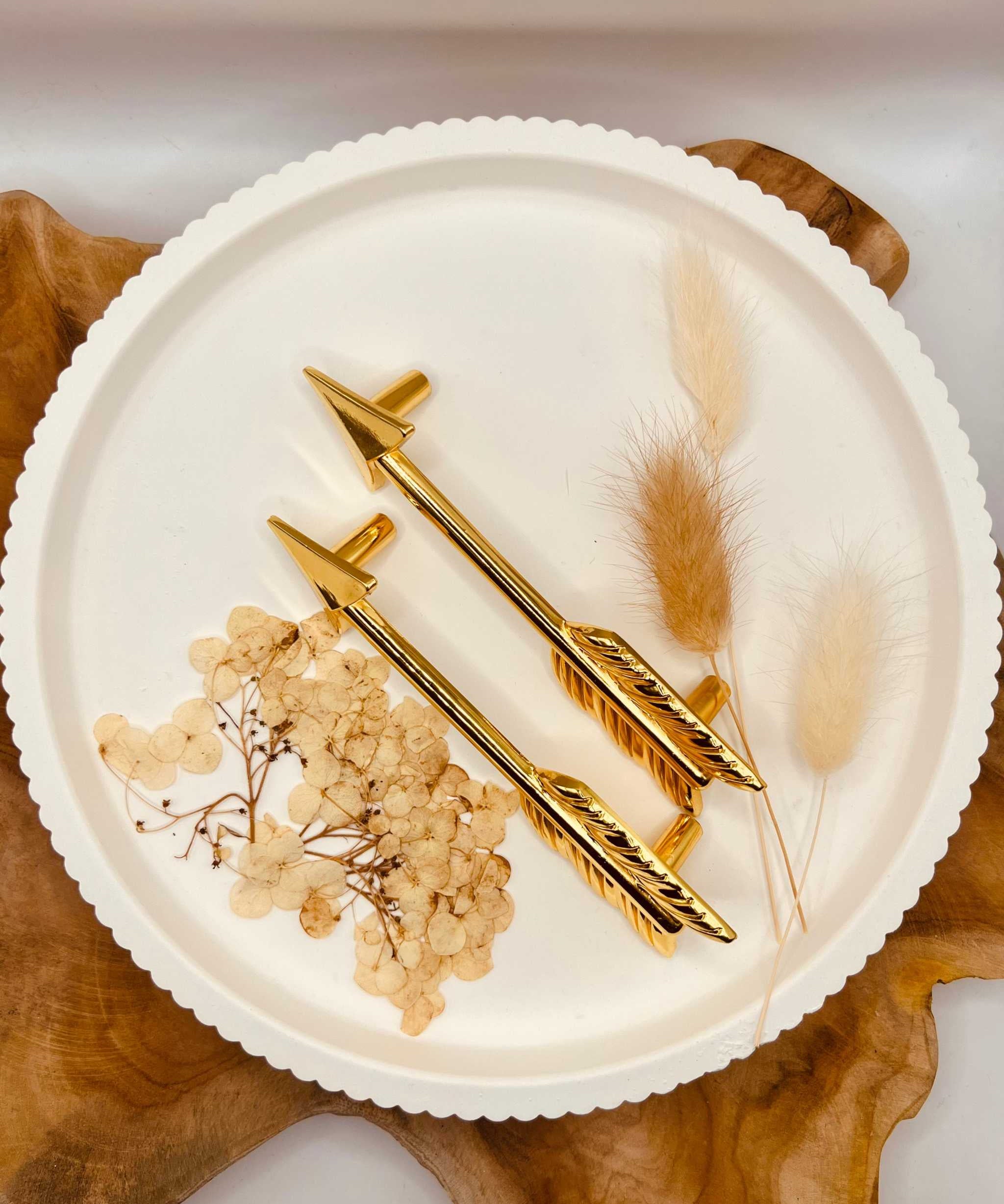 Gold-colored tray handles "The Arrow" set of 2 on decorative plate.