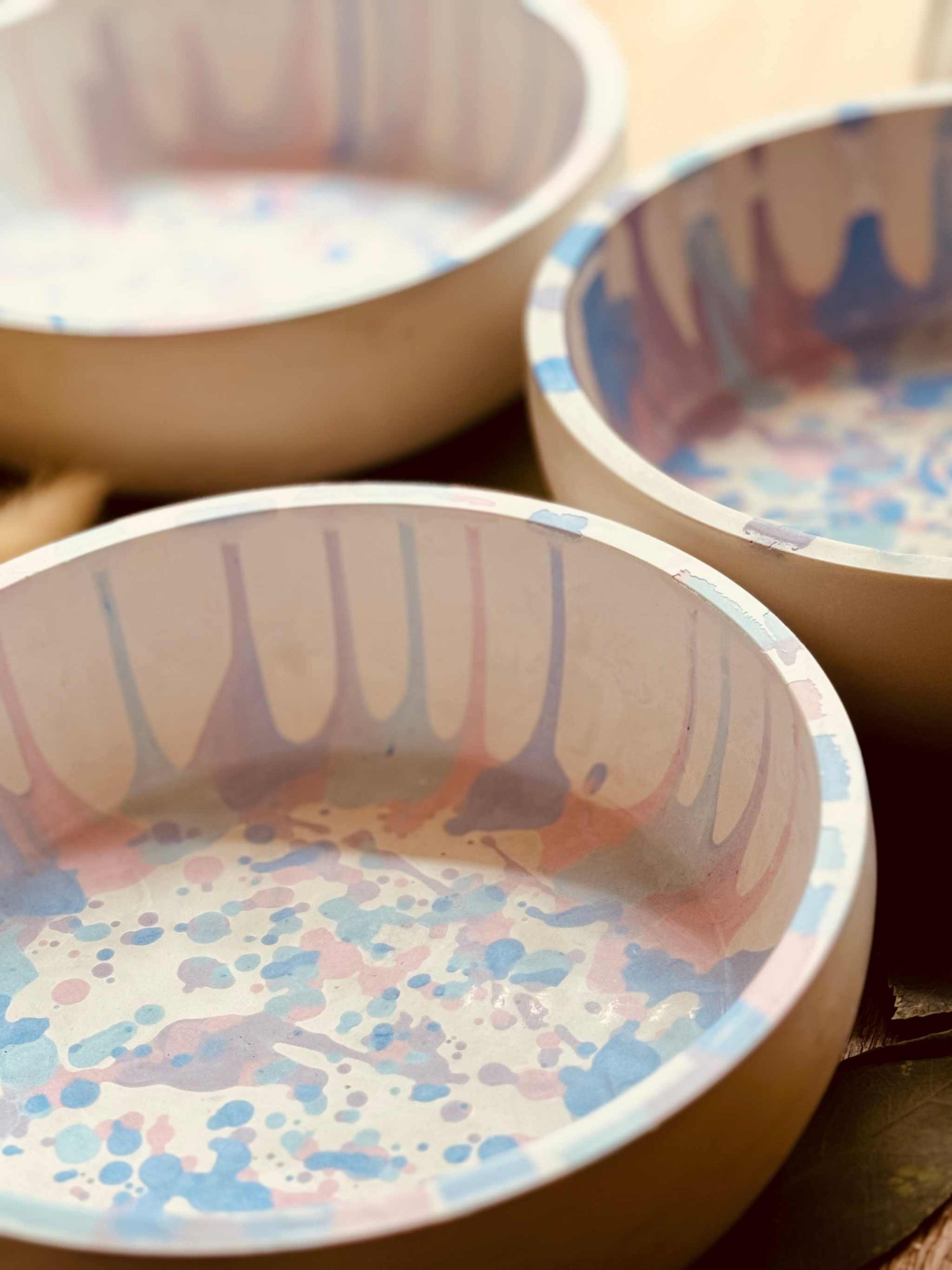 Gießkeramik-Schalen mit farbigen Tropfen- und Sprenkelmustern in Rosa und Blau, perfekt als Dekoration oder für die Aufbewahrung kleiner Gegenstände.