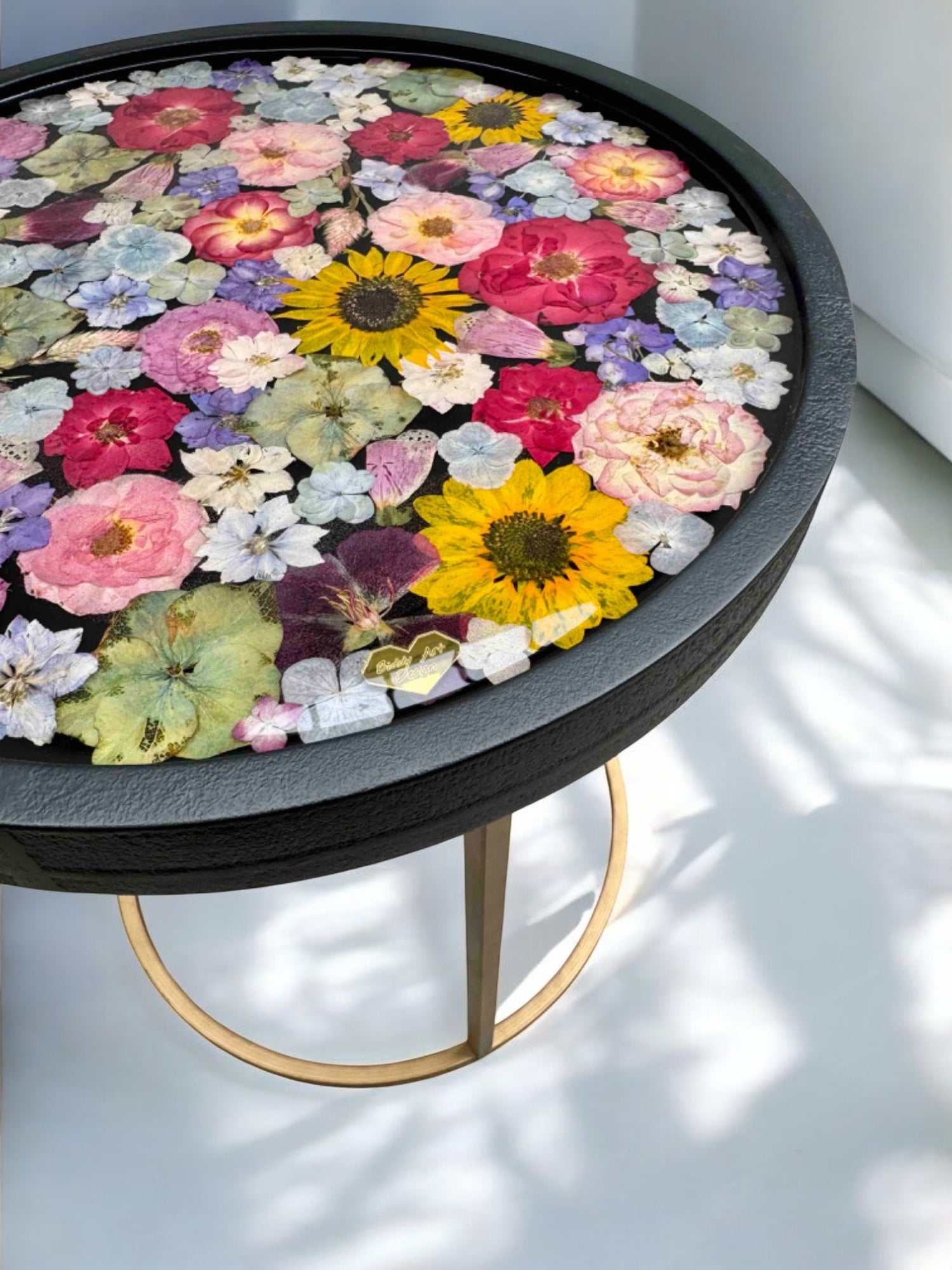 Brautstrauß konservieren -  Kunstvoller Blumentisch mit Epoxidharz-Oberfläche und echtem Blumendesign – Kombination aus Schwarz, Gold und bunten Blüten für modernes Wohnambiente.Auch mit deinem Brautstrauß zur Brautstrauss Konservierung