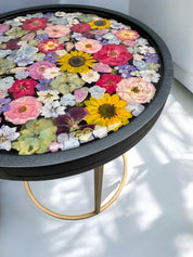 Brautstrauß konservieren -  Kunstvoller Blumentisch mit Epoxidharz-Oberfläche und echtem Blumendesign – Kombination aus Schwarz, Gold und bunten Blüten für modernes Wohnambiente.Auch mit deinem Brautstrauß zur Brautstrauss Konservierung