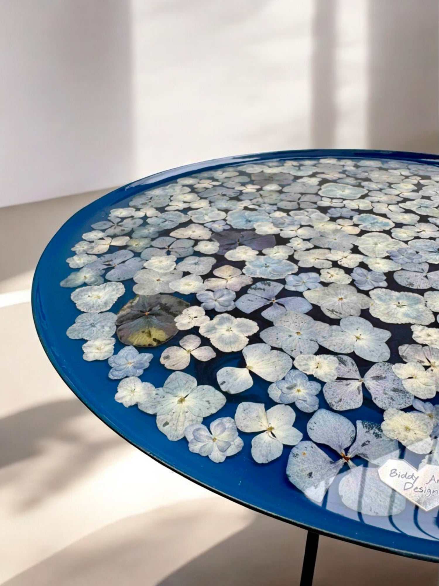 Moderner Epoxidharz Couchtisch mit einzigartiger Blumenoptik – blauer Rand und runde Platte mit Naturdetails, handgefertigt