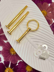Nahaufnahme des minimalistischen Ringdesigns an der Etagerenstange -DIY-Etagere mit goldener Stange und Blattgold-Elementen
