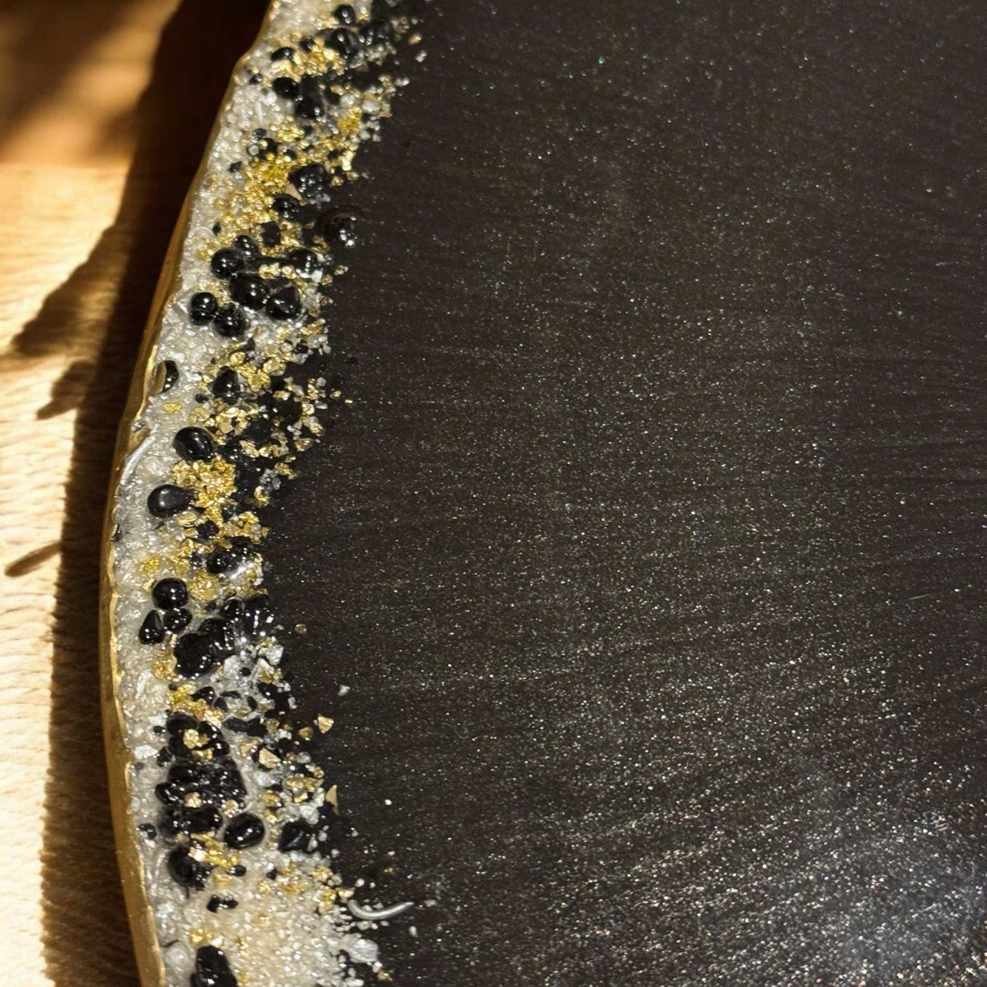 Unikat Epoxidharz Couchtisch mit filigranem Metallgestell, Resin-Tischplatte in Schwarz und Gold, ideal als Hingucker im Wohnzimmer.