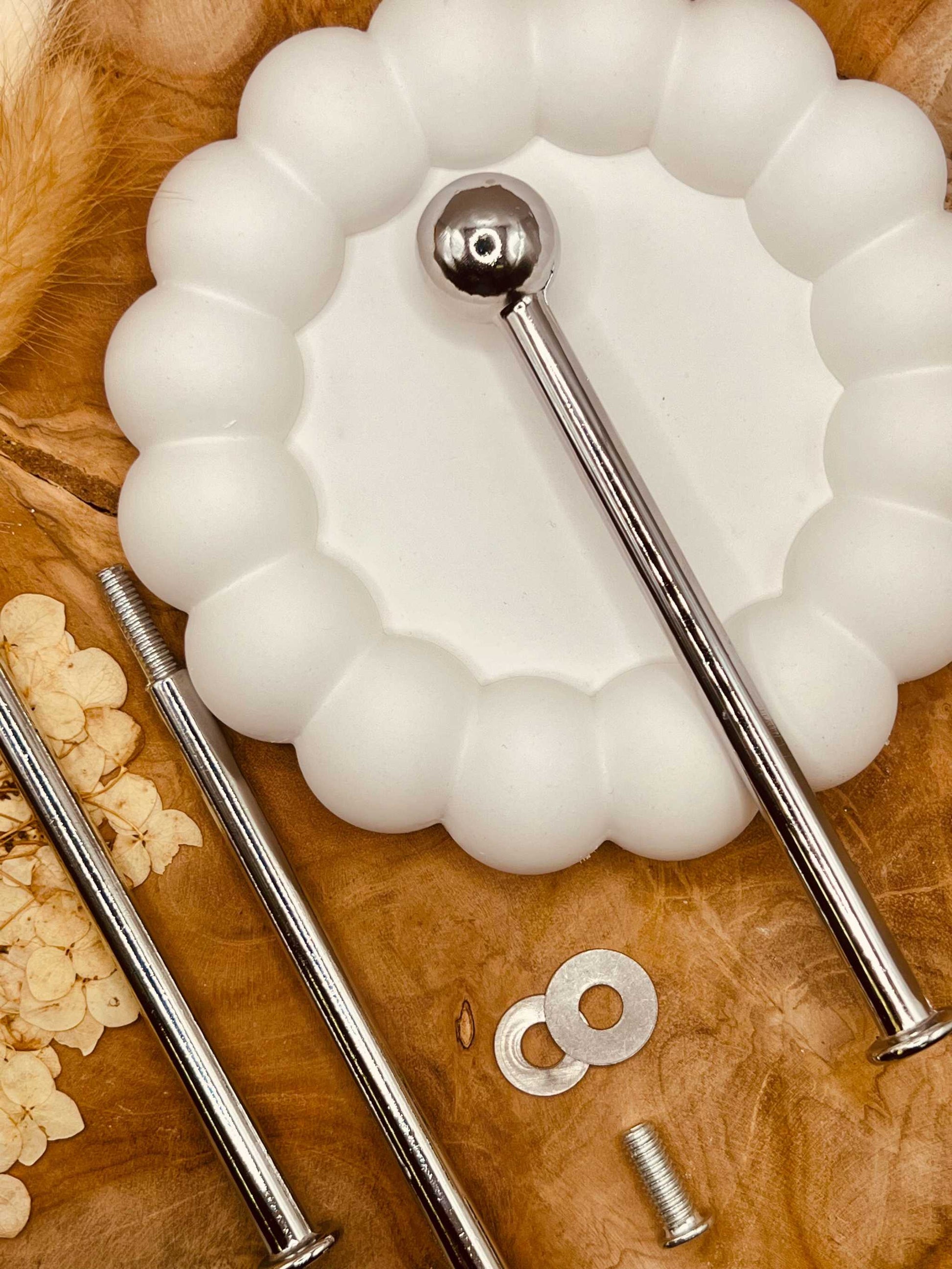 Einzelteile der silberfarbenen Etagerenstange mit Schrauben und Zubehör