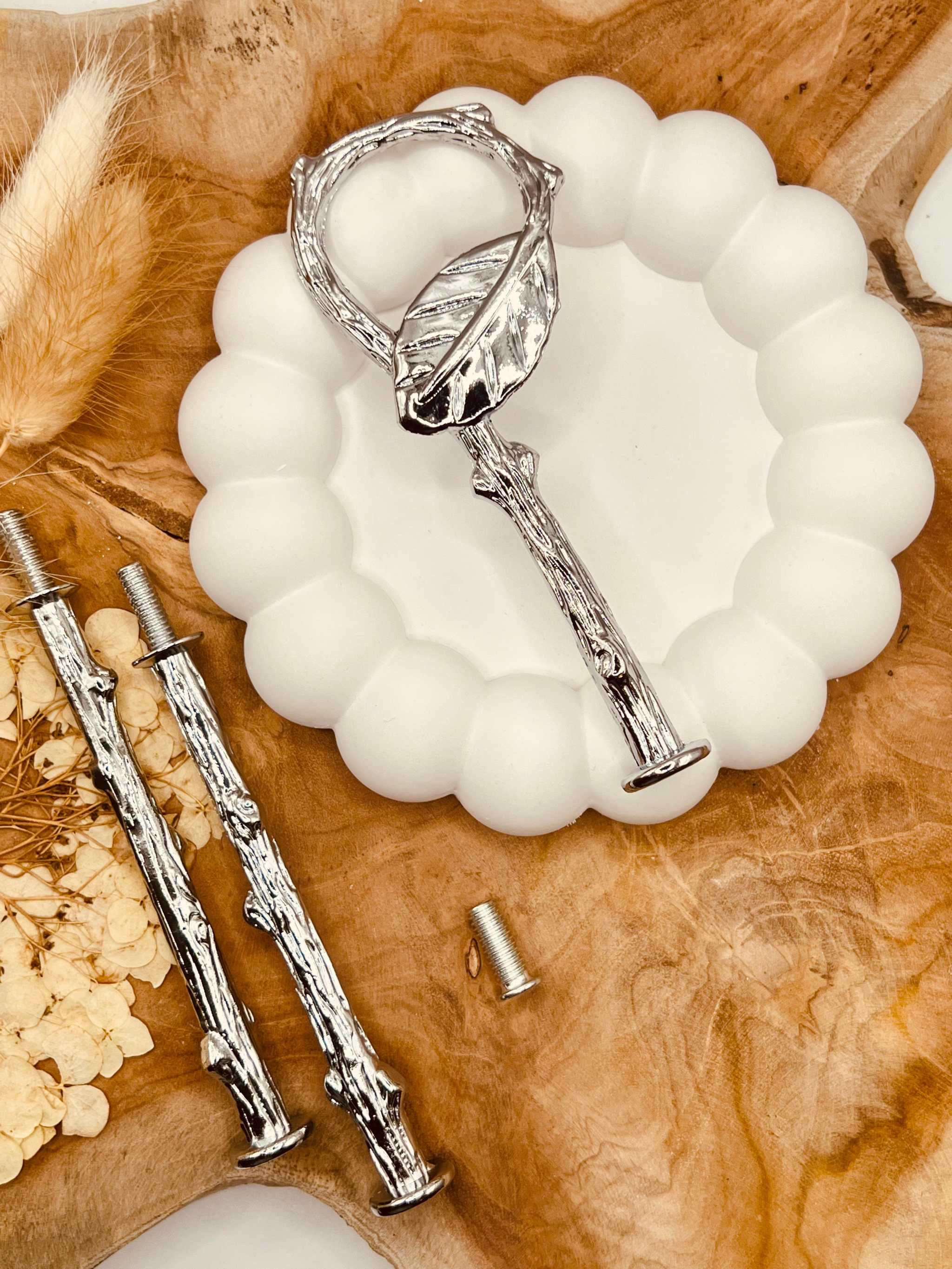 Silberne Etagerenstange auf runder Marmordeko arrangiert