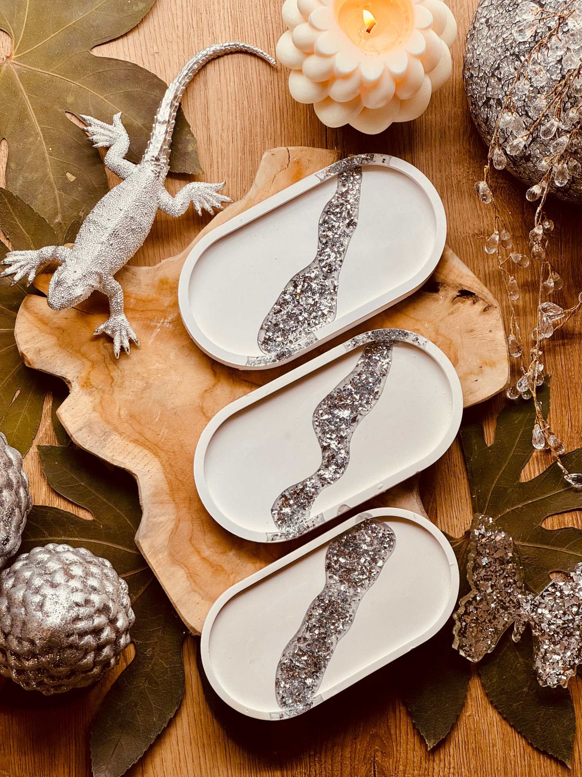 Ovale Schmuckschale aus Gießkeramik mit glitzerndem Blattsilber-Detail, ideal für die stilvolle Präsentation von Schmuck oder als dekoratives Element.Weisse Deko Schale aus Giesskeramik mit Silber Details