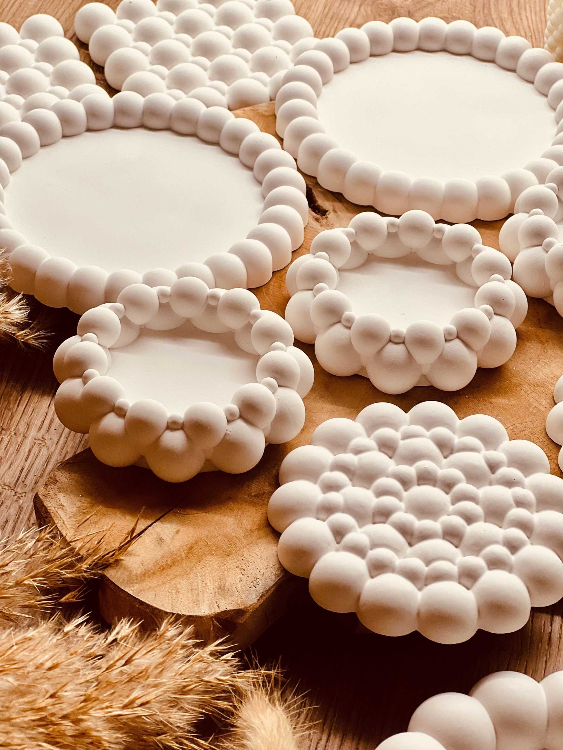 Handcrafted Gießkeramik Untersetzer "Many Bubbles" with unique bubble design on wooden surface.Weisse Deko Tablett Giesskeramik Many Bubbles handmade