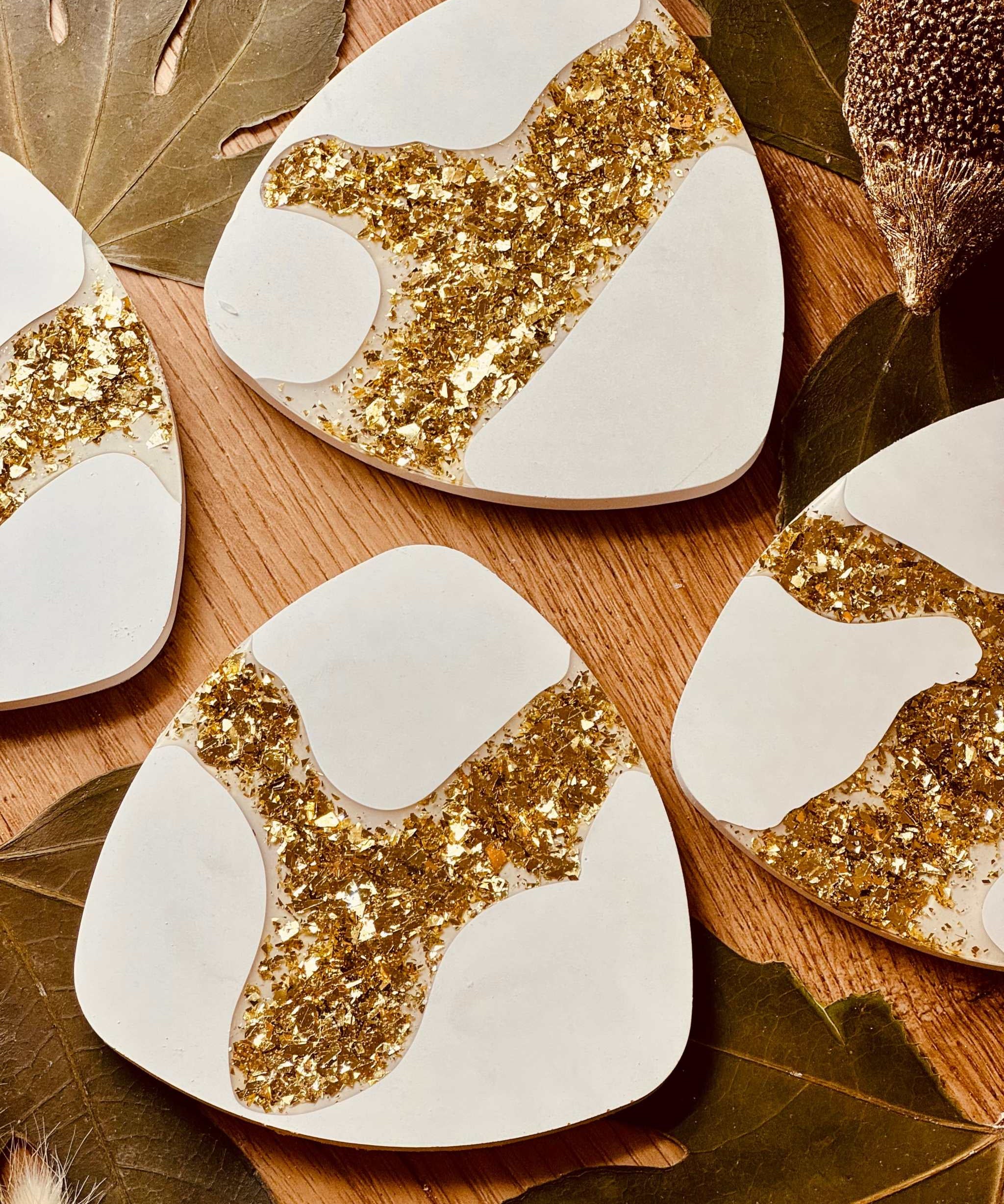 4er-Set Untersetzer aus Gießkeramik mit goldenen Resin-Akzenten, handgefertigt und ideal für elegante Tischdekorationen.Weisse Deko Untersetzer aus Giesskeramik mit Goldoptik