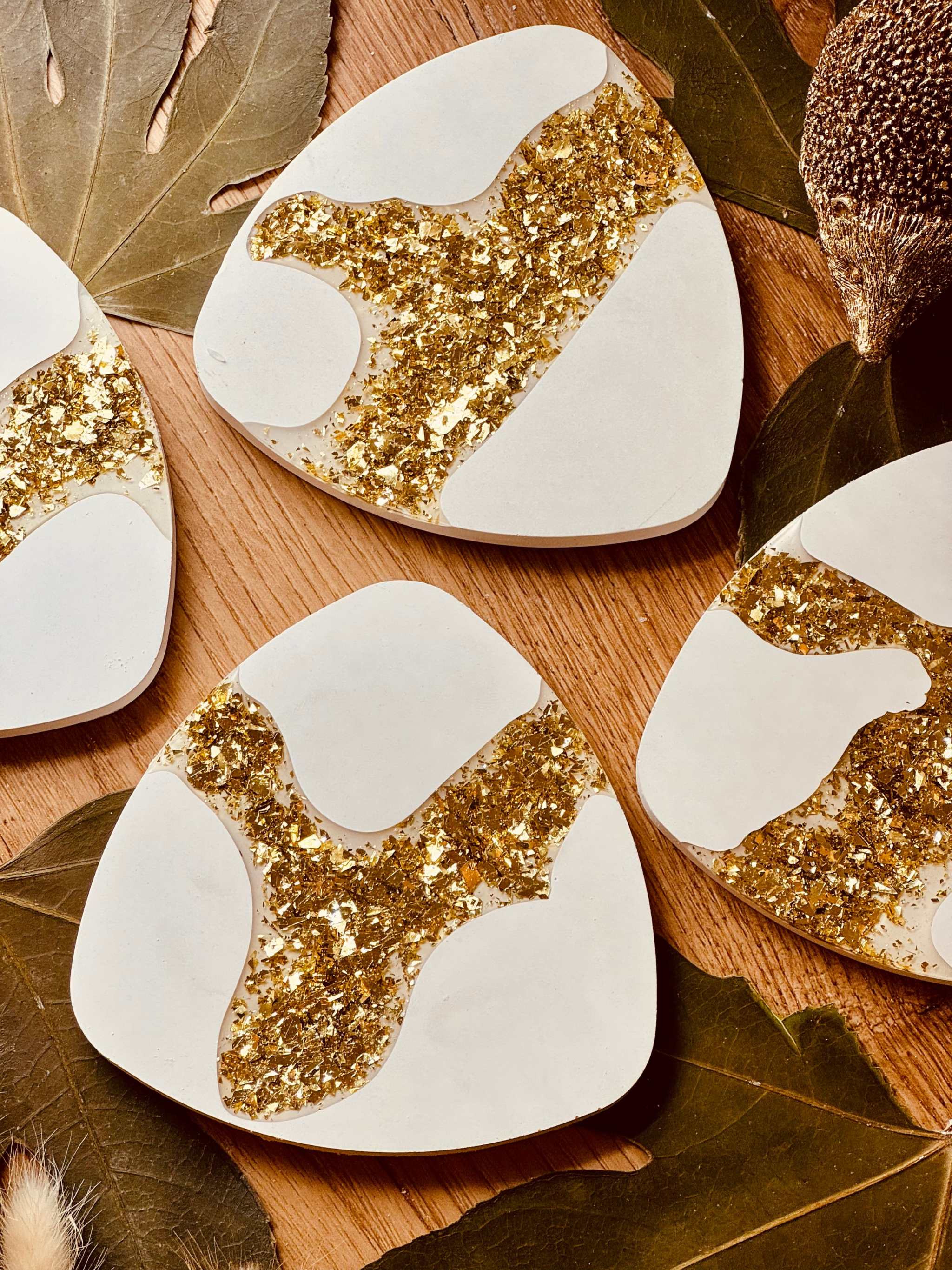4er-Set Untersetzer aus Gießkeramik mit goldenen Resin-Akzenten, handgefertigt und ideal für elegante Tischdekorationen.Weisse Deko Untersetzer aus Giesskeramik mit Goldoptik