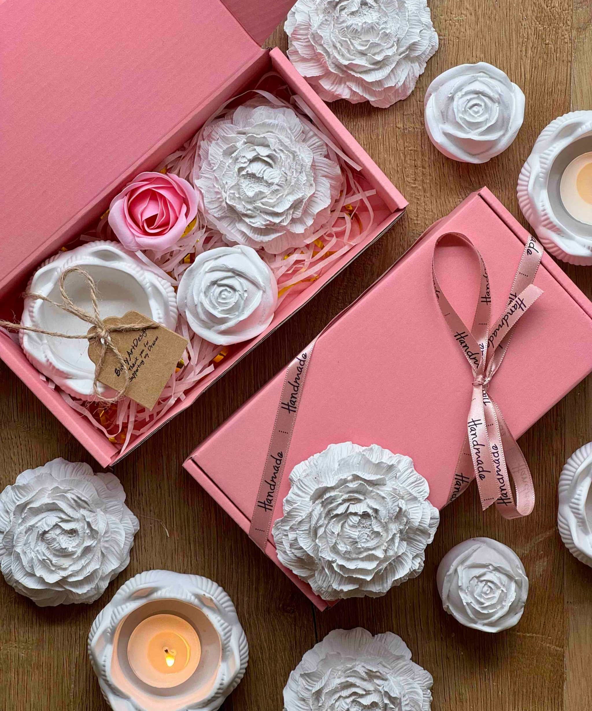 Dekorative Geschenkbox in Rosa, gefüllt mit Keramikblumen und Teelichtern – eine liebevolle Geschenkidee für besondere Momente.Weisse Deko mit handgemachte Kerzen und romantischer Giesskeramik im Geschenkset