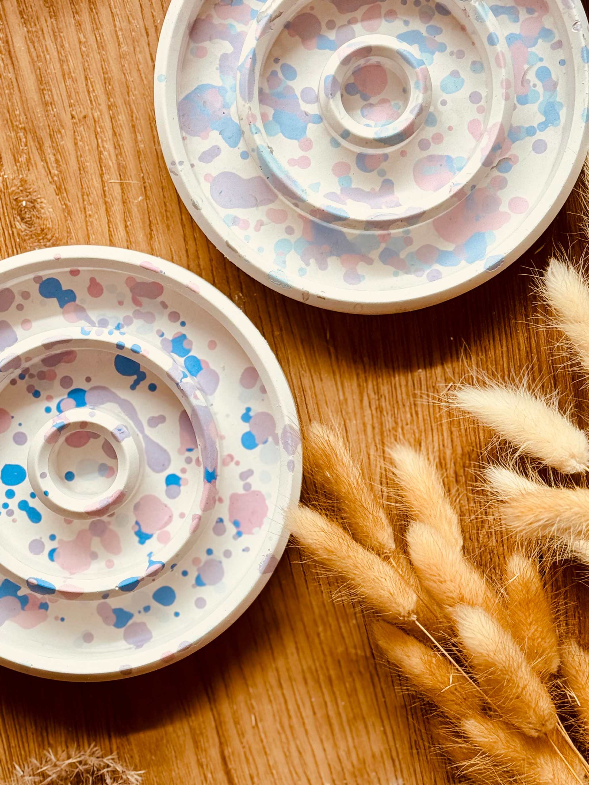 Runder Stabkerzenhalter aus weißer Gießkeramik mit zartem Pastellspritzmuster, einzeln erhältlich, perfekt für festliche oder alltägliche Dekorationen.