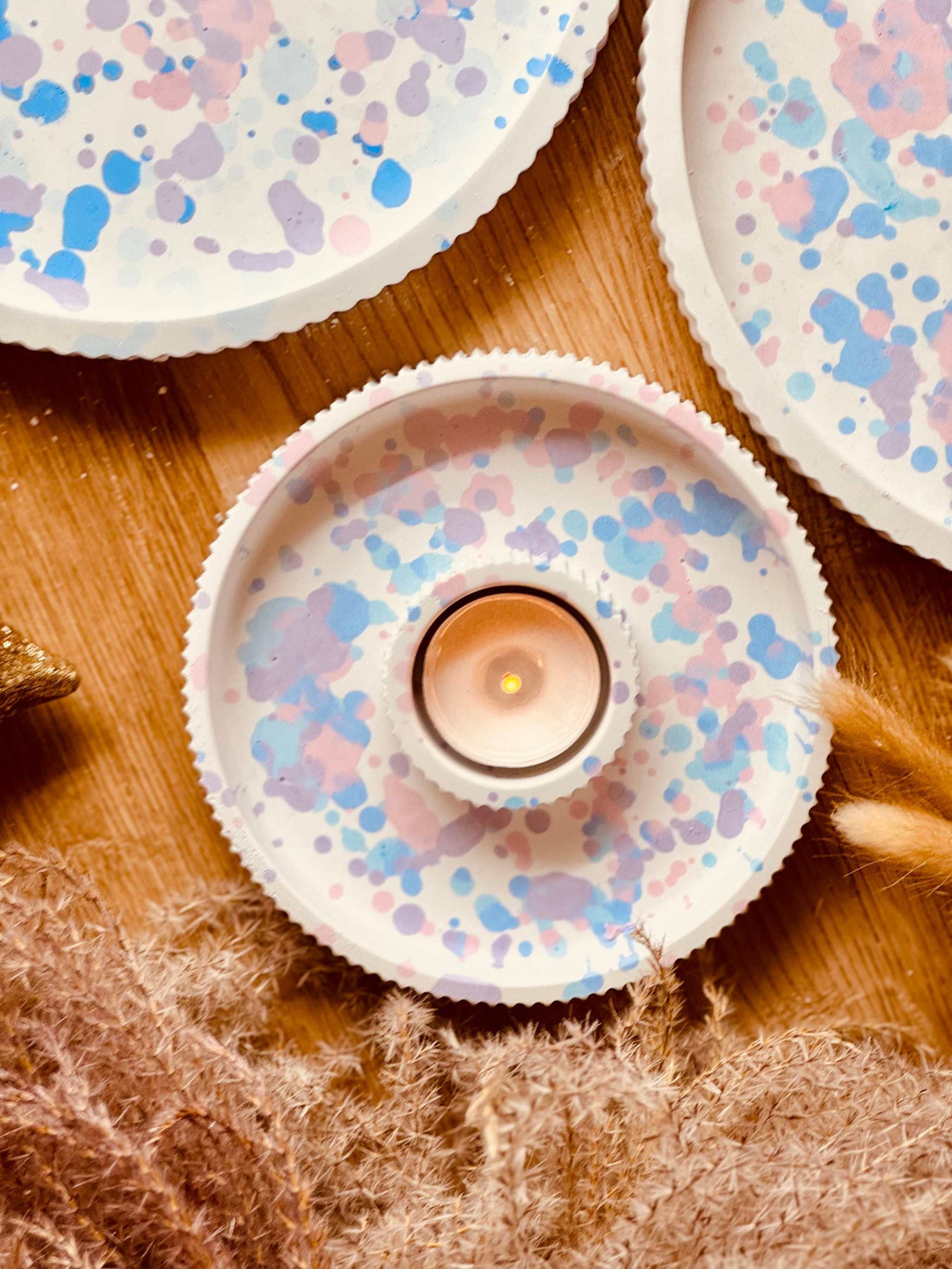 Dekorative Gießkeramik-Tabletts in zarten Pastellfarben mit handgefertigten Sprenkelmustern, ideal als Basis für Kerzenhalter und andere dekorative Elemente.