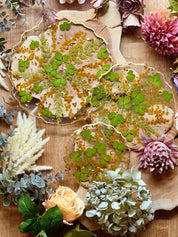 Einzigartige Epoxidharz Etagere mit Blattgold und natürlichen Akzenten wie Erdbeerblättern und Akazienblüten, ideal für dekorative Zwecke.