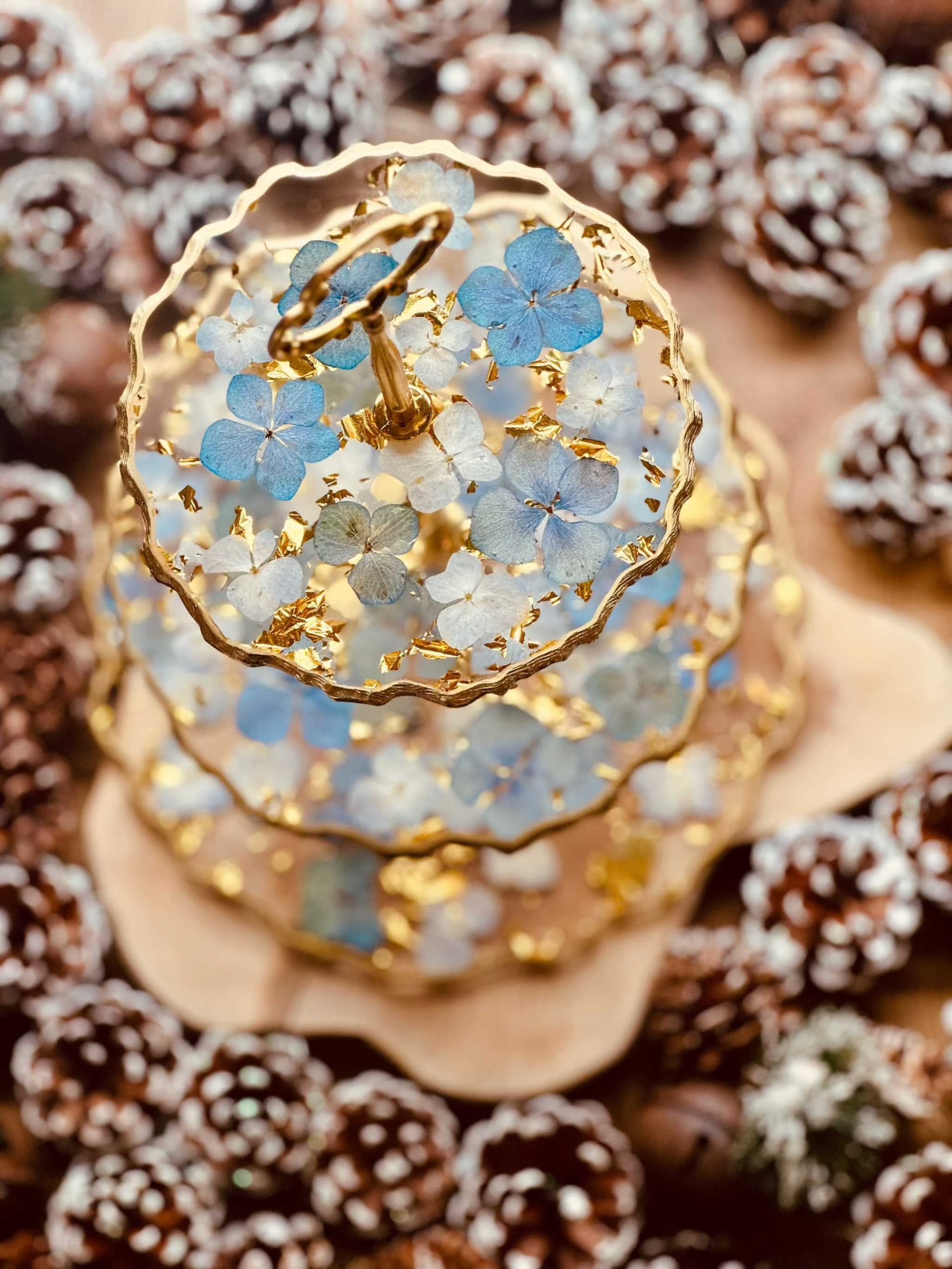 Luxuriöse 3-stöckige Epoxidharz Etagere mit blauen Hortensien und Blattgold, handgefertigt und einzigartig, ideal für besondere Anlässe.
