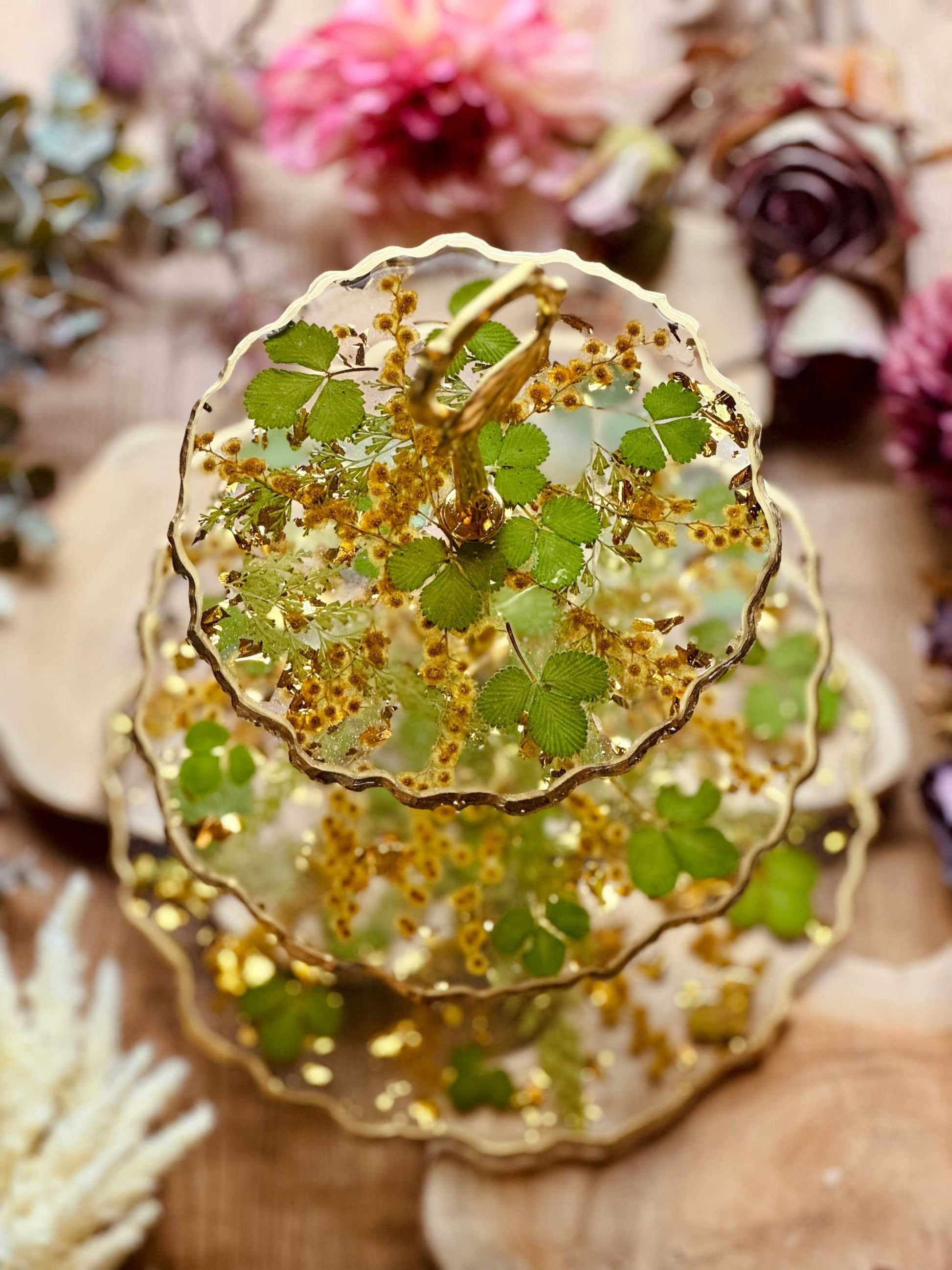 Handgefertigte 3-stöckige Etagere aus Epoxidharz, verziert mit Akazienblüten, Erdbeerblättern und Blattgold, perfekt für besondere Feiern.