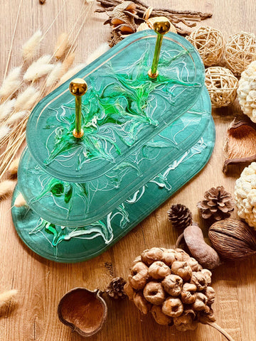 Oval resin cake stand with elaborate design in green with gold