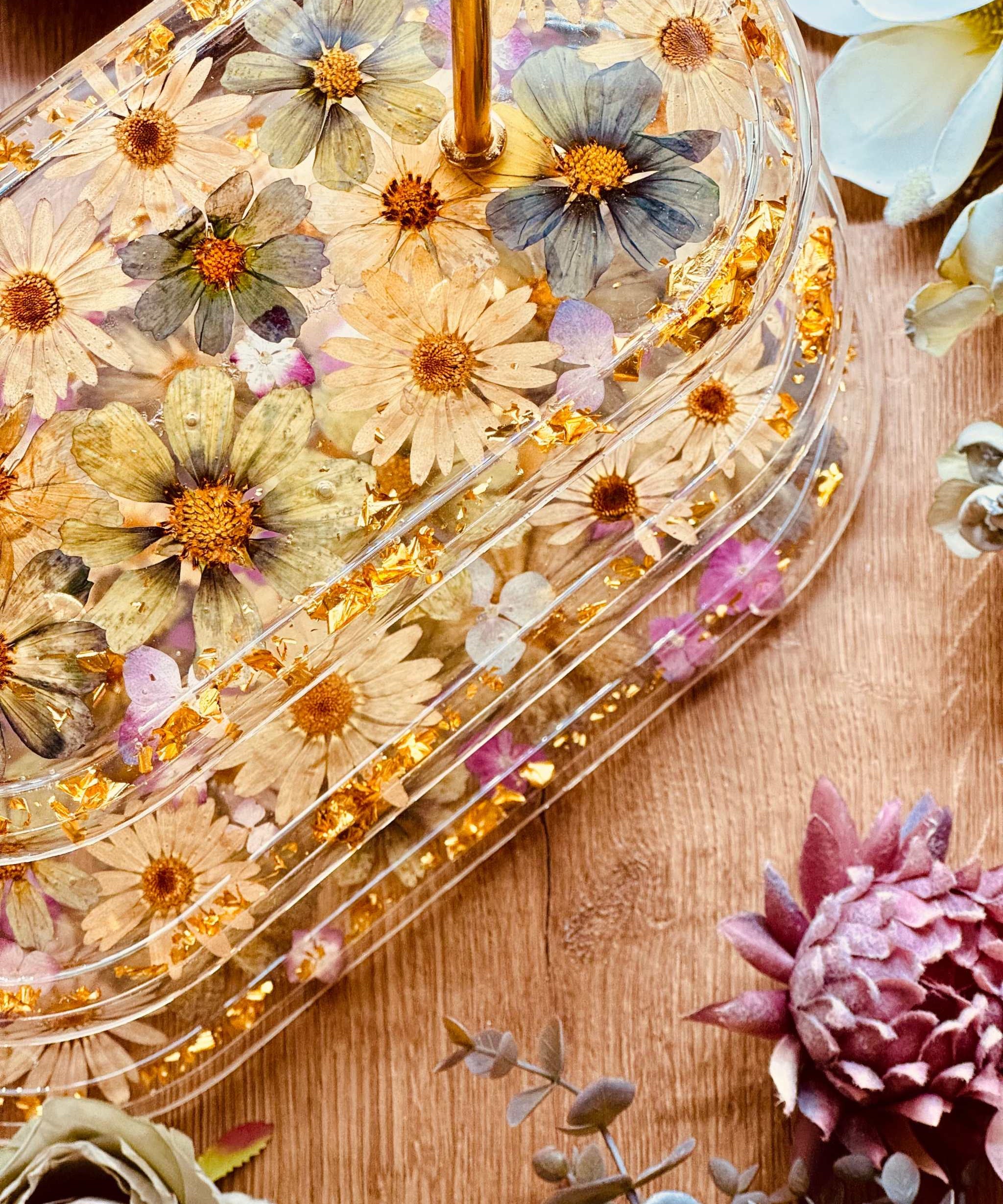 Elegante 3-stöckige Epoxidharz Etagere in ovaler Form mit Blattgold, großen Blüten und Hortensien, perfekt für festliche Tischdekorationen.