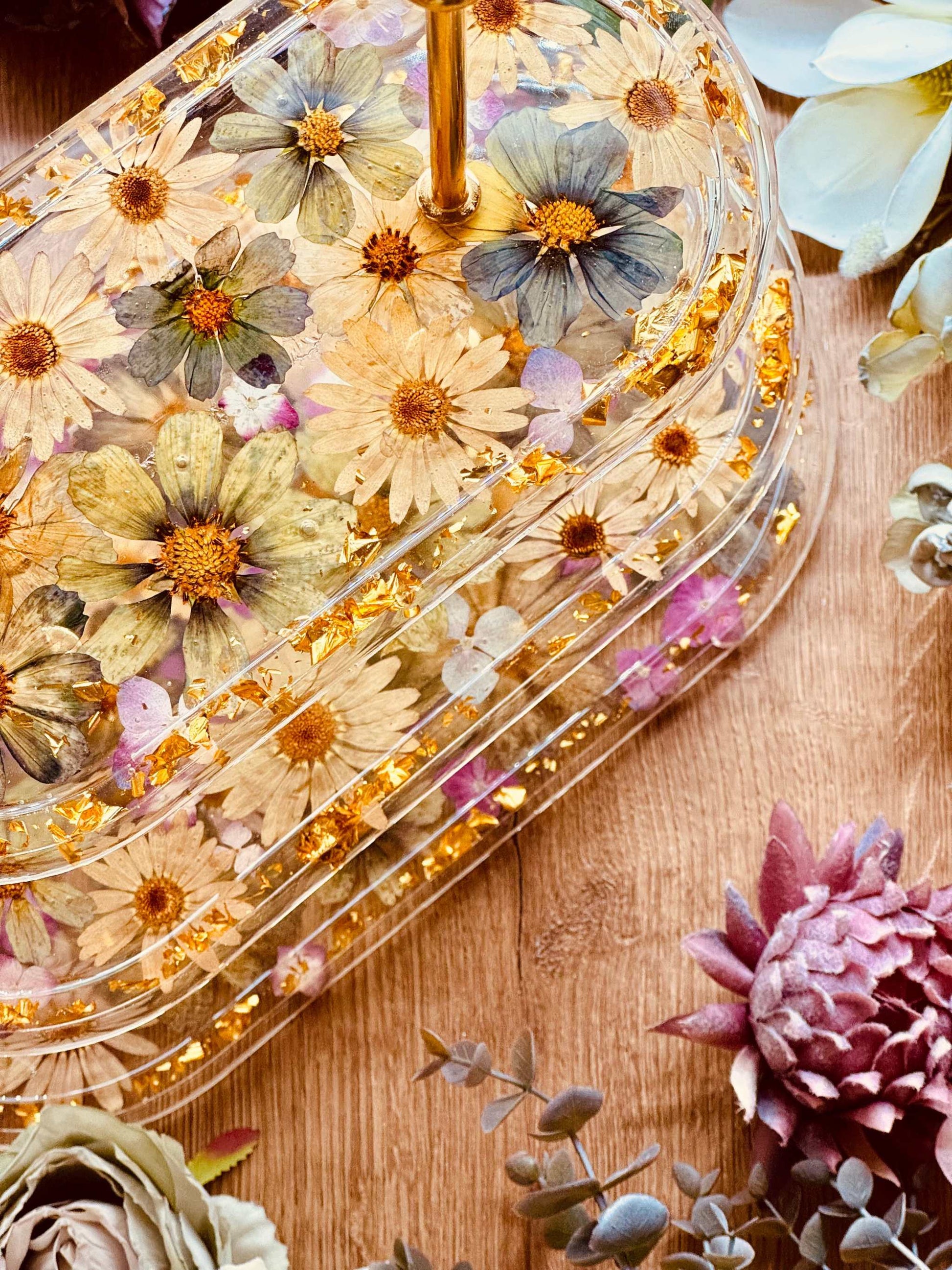 Elegante 3-stöckige Epoxidharz Etagere in ovaler Form mit Blattgold, großen Blüten und Hortensien, perfekt für festliche Tischdekorationen.
