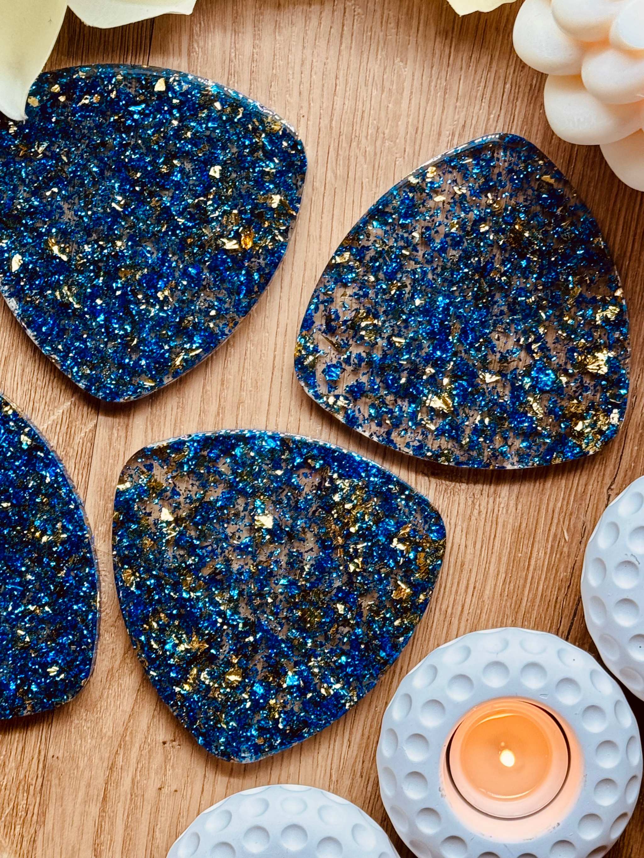 4 handgemachte blaue Resin Untersetzer mit goldenen Details auf Holztisch dekorativ angeordnet