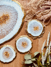 weißes Resin Tablett und 4 Untersetzer mit goldenen Akzenten im Achat Design auf Holztisch