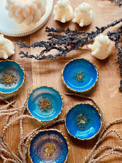 Handgemachte Schmuckschalen aus Resin in Blau und Türkis mit goldenen Details auf Holztisch dekoriert