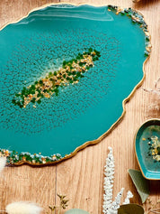 Grünes handgemachtes Tablett aus Resin mit goldenen Details und glitzernden Dekosteinen auf Holzuntergrund