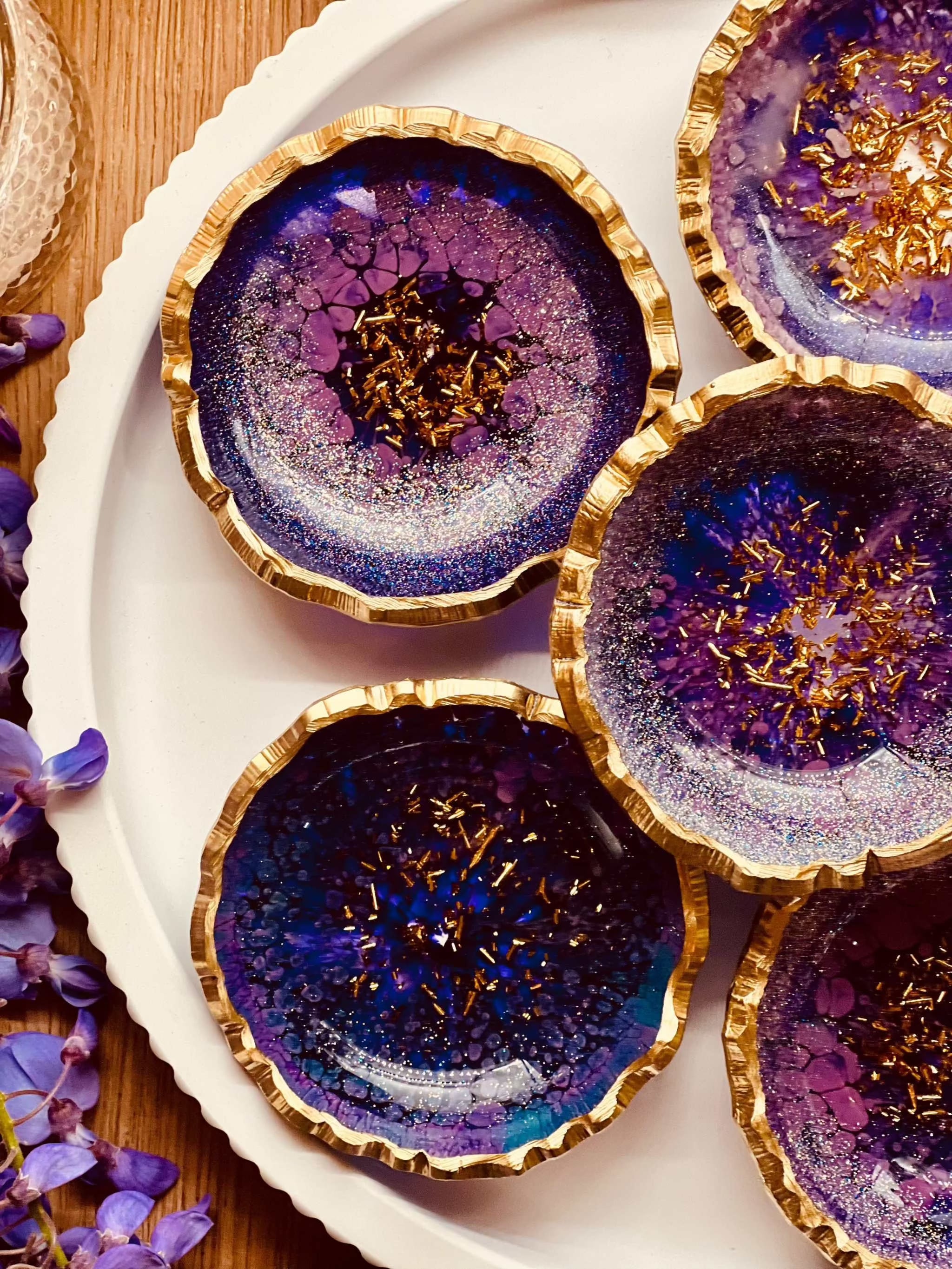 Schmuckschalen aus Resin in lila mit goldenen Details auf weißem Teller, handgemachte Dekoration für Schmuck und Ringe