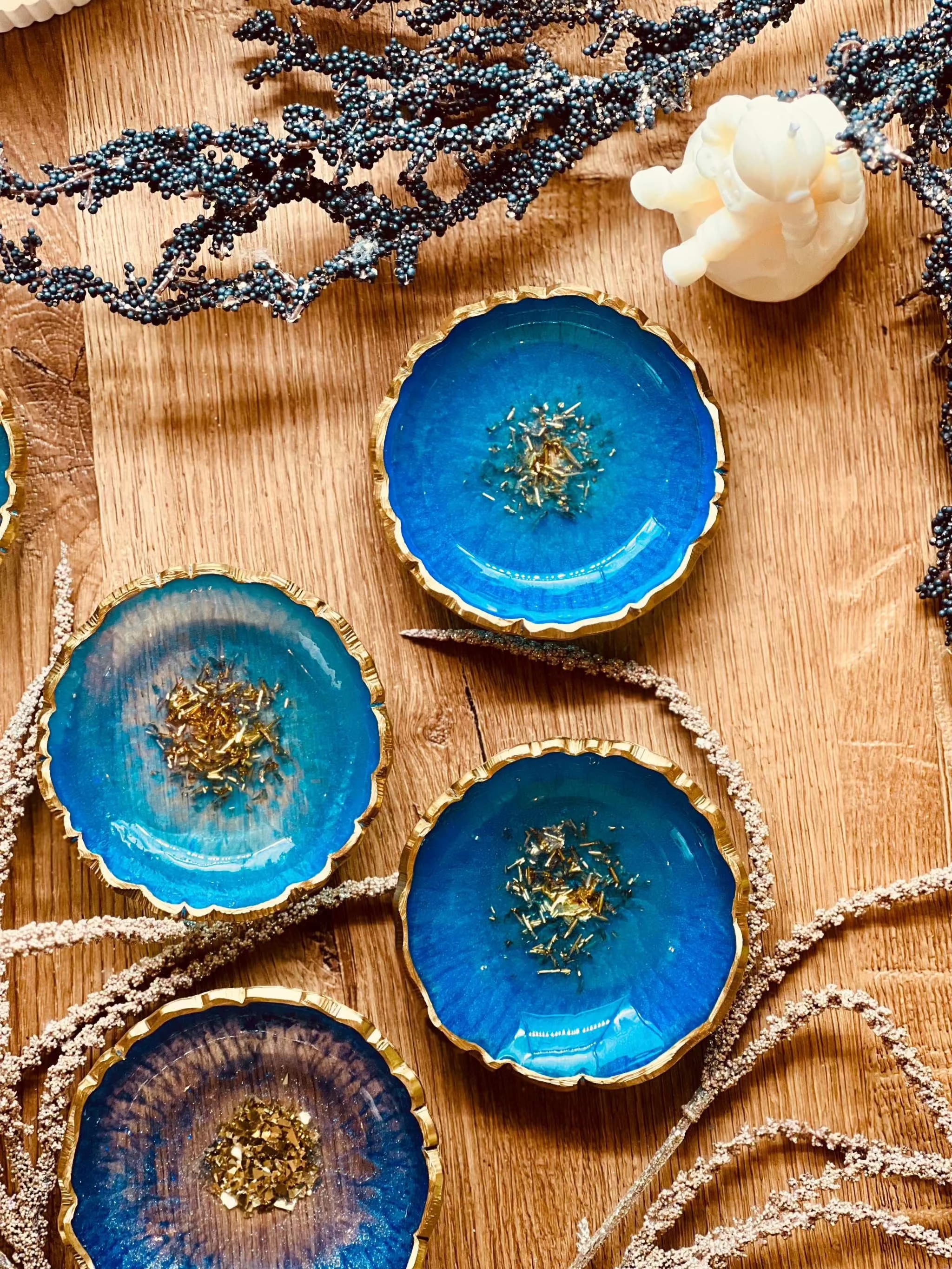 Handgemachte Schmuckschalen aus Resin in Blau und Türkis mit goldenen Details auf Holztisch