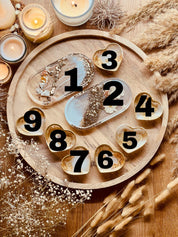 Handgemachte Schmuckschalen aus weißem Resin mit goldenen Details, Perlmutt und Blumen in verschiedenen Formen auf Holztablett