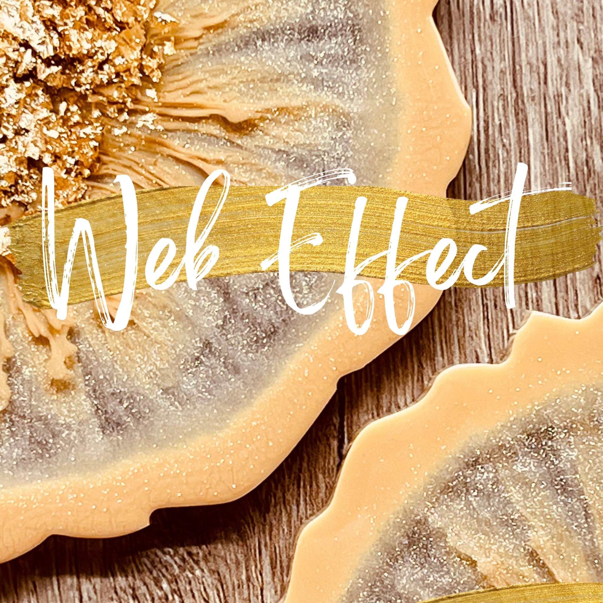 Resin art web effect with metallic gold accents on decorative pieces.